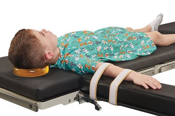 pediatric patient on operating table with safety straps and gel head positioner
