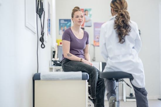 nurse talking to woman in check up room