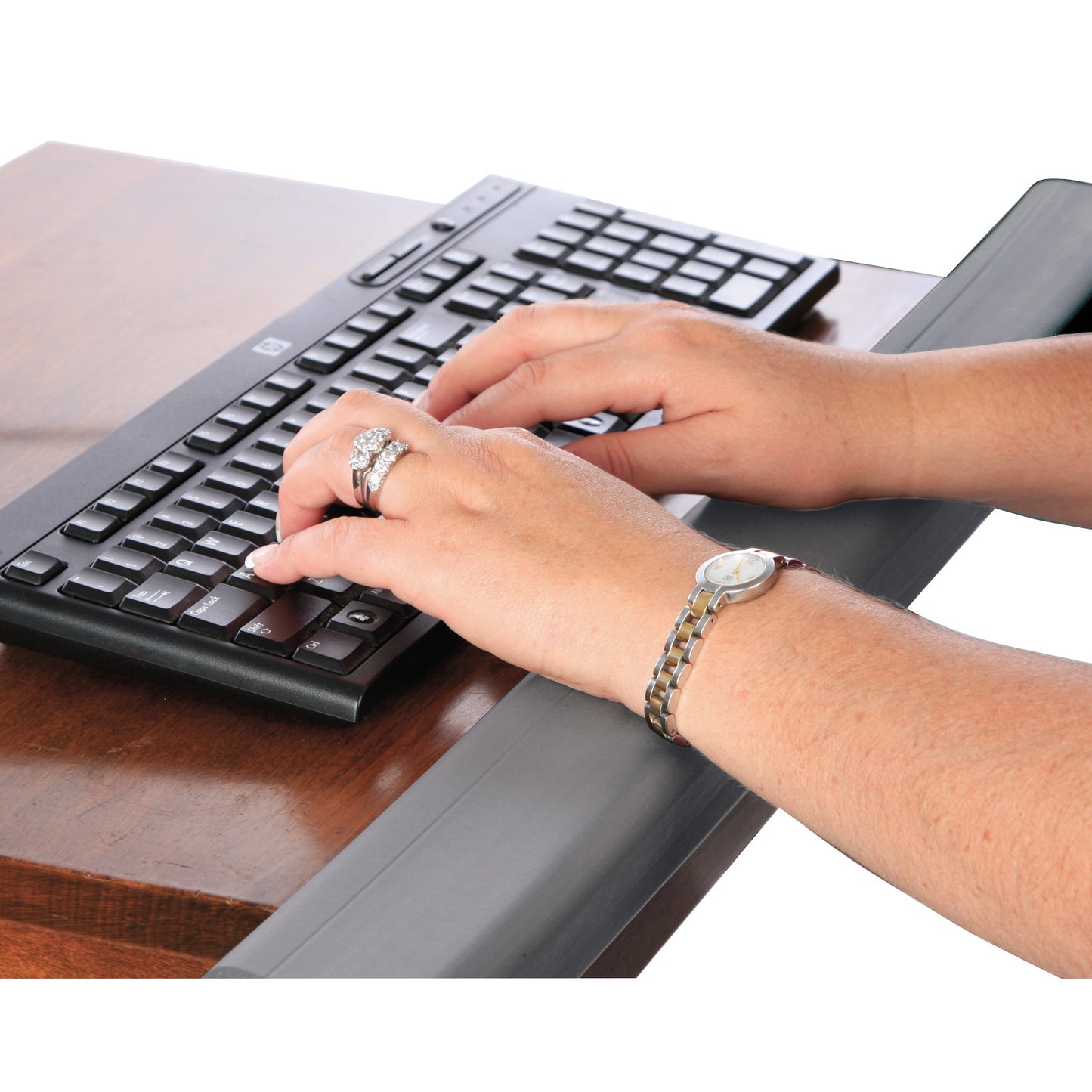 Hands typing on a keyboard with an AliMed SoftEdge Edge Protector on the desk, providing ergonomic comfort and wrist support.