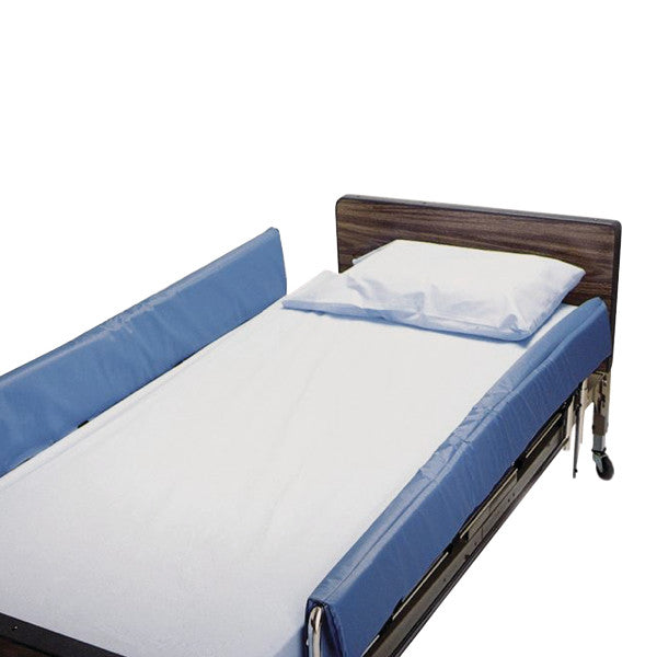 A hospital bed with SkiL-Care Cushion-Top Vinyl Bed Rail Pads in blue, featuring wooden headboard and a white pillow and sheet.