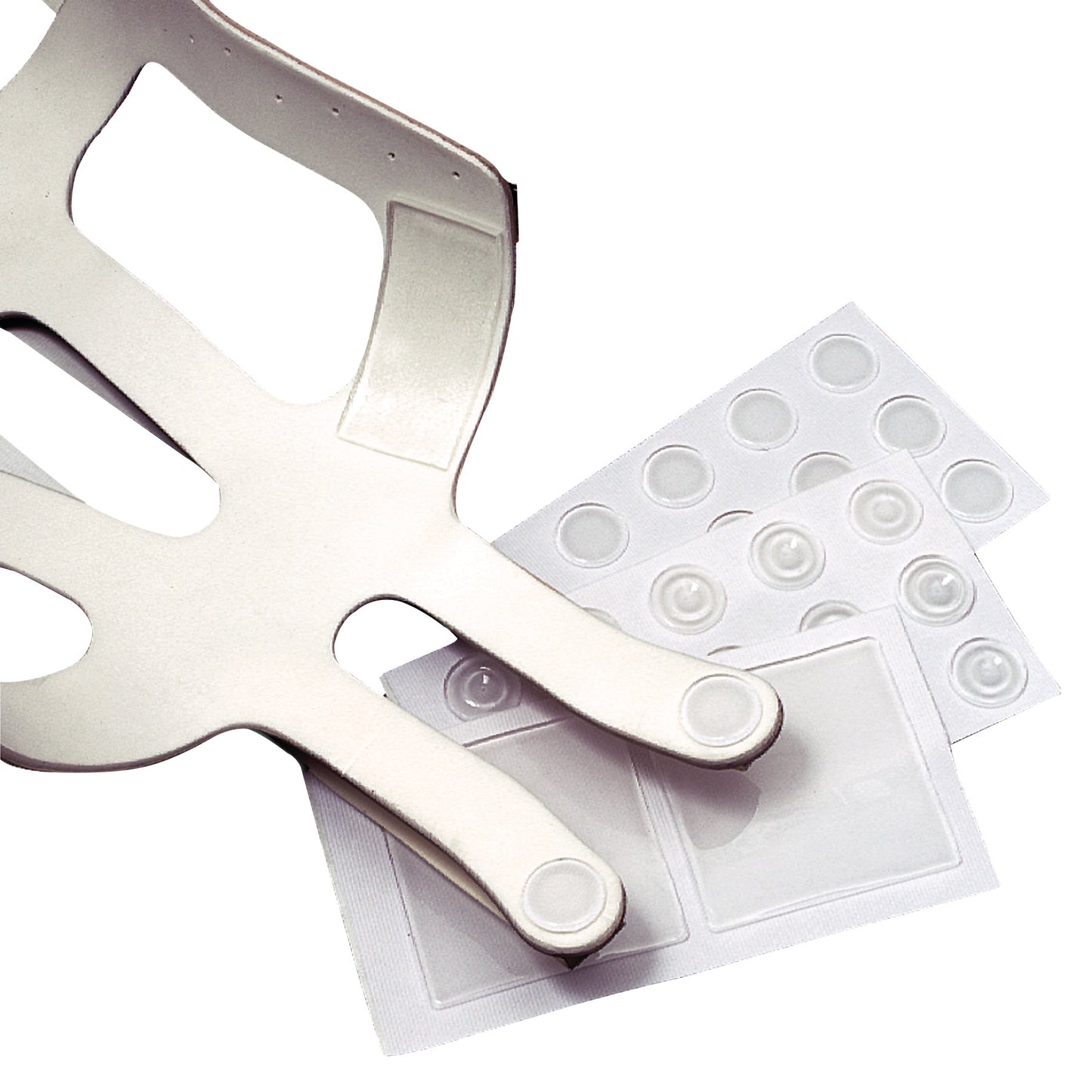Silipos Gel Dots and Squares alongside a plastic frame featuring cutouts and two rounded extensions, likely for medical use.