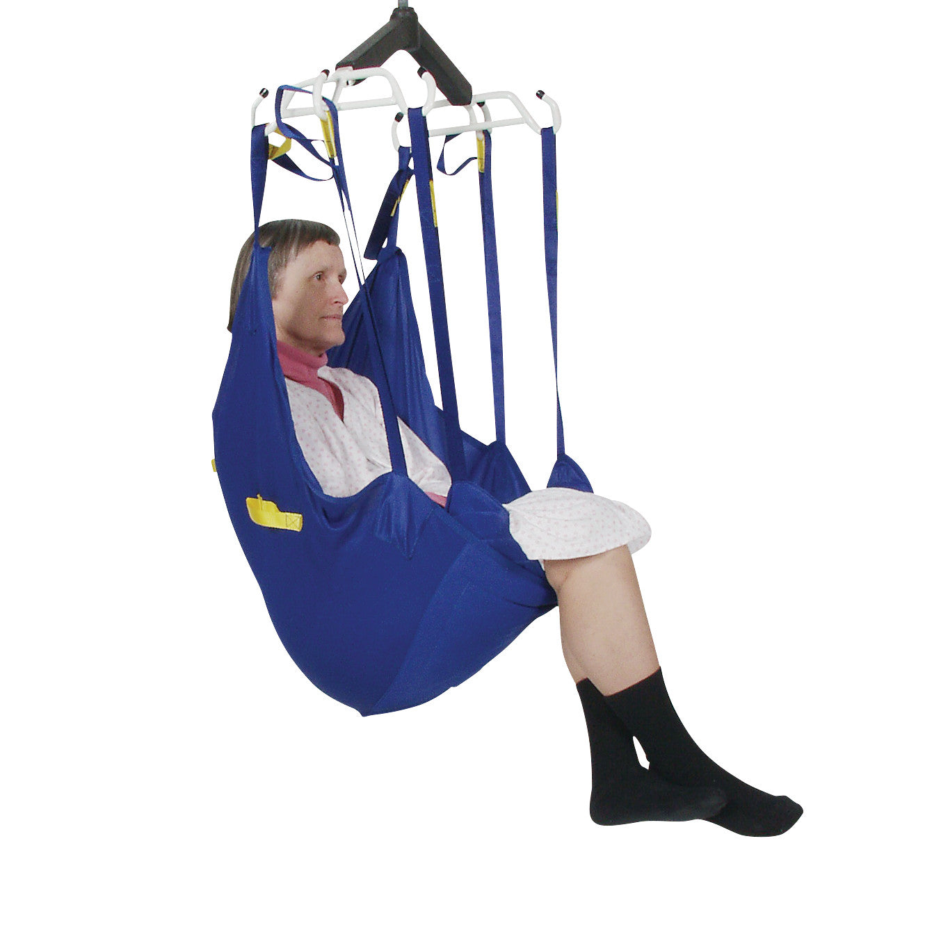 A person is seated in a blue Bestcare BestSling Universal Patient Sling, supported by adjustable straps and hanging from a lift.