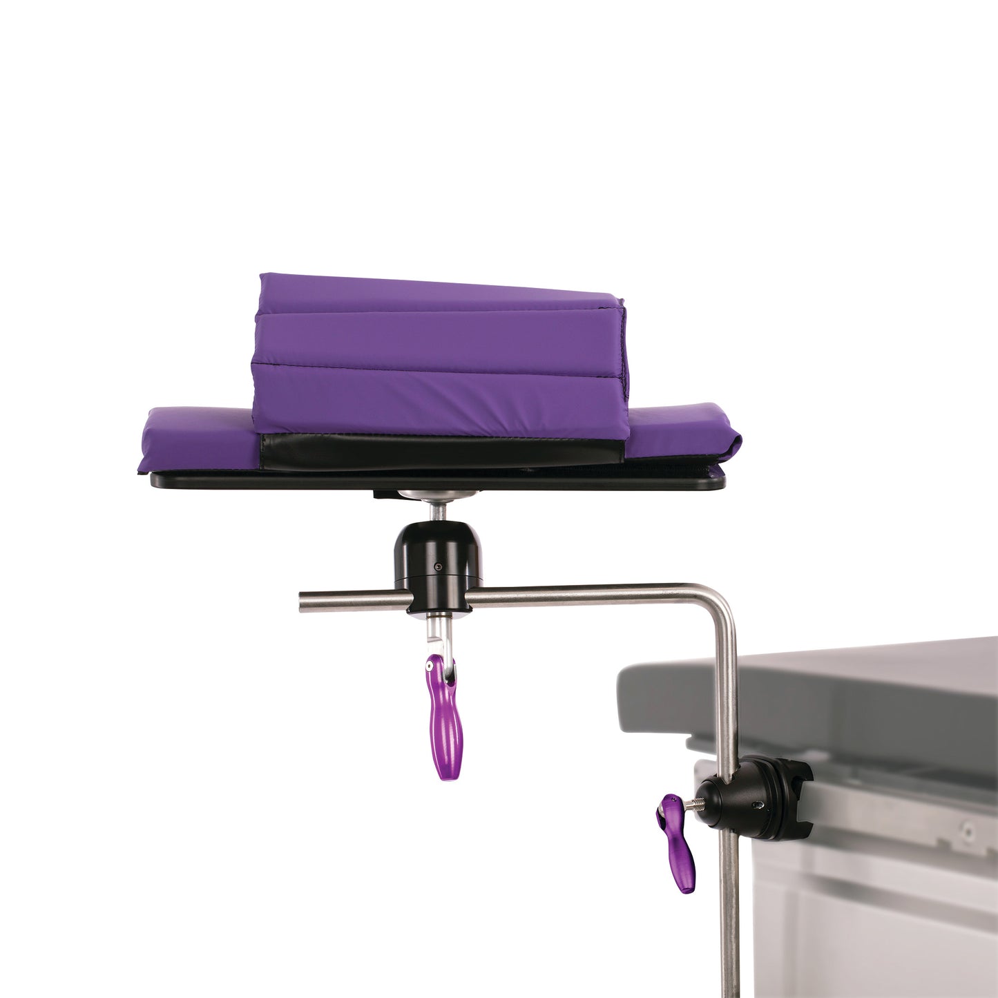 KYRA Swivel Armboard with purple padding attached to a metal frame, shown clamped beside a gray surface, likely a medical table.