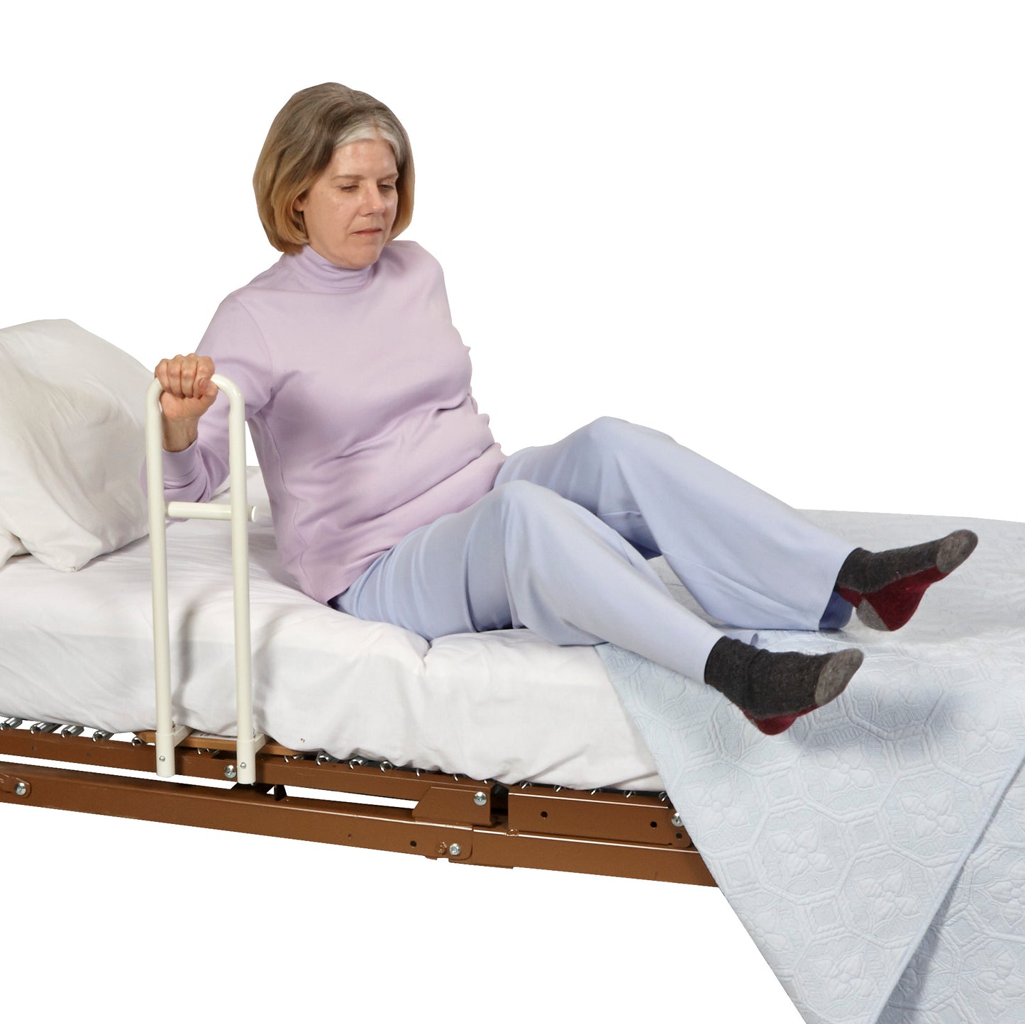 A person uses the Transfer Handle Hospital Model for Pan-Style Beds, gripping the handle to assist in sitting on the bed.
