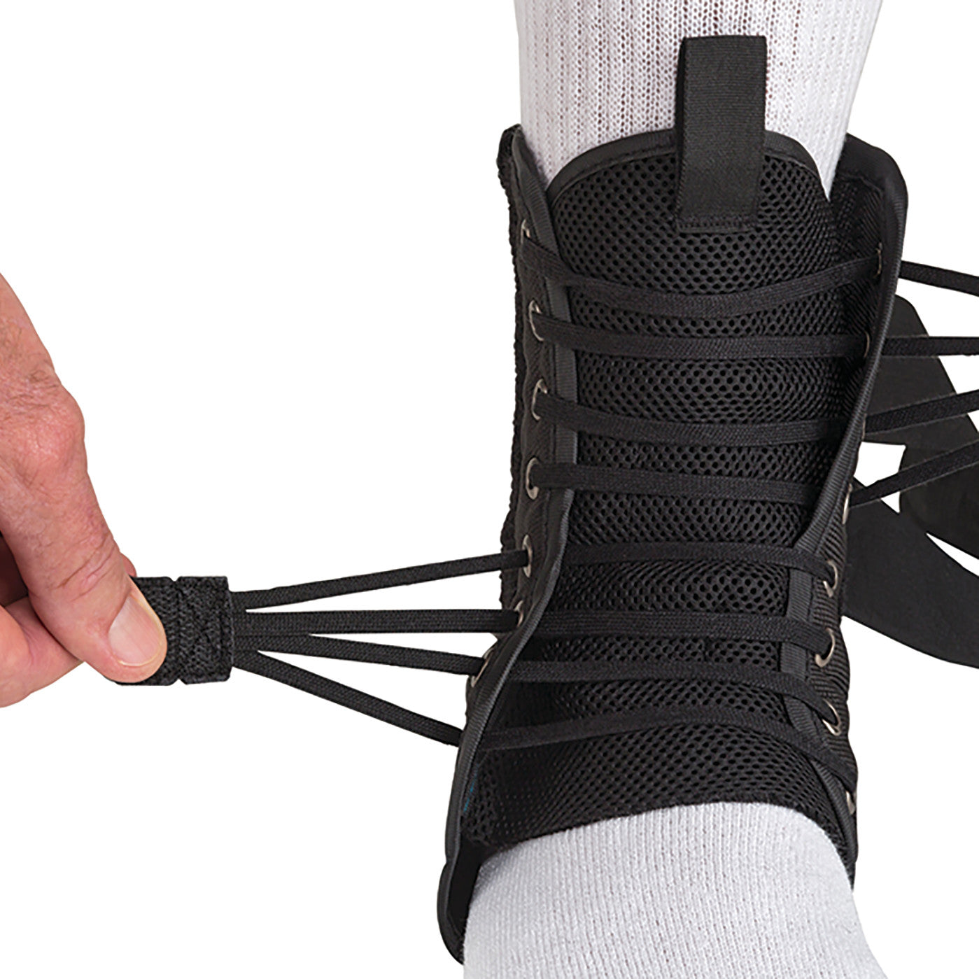 A person tightens an �ssur Formfit Ankle Brace with Speedlace over a white sock, showcasing its lace-up design for support.