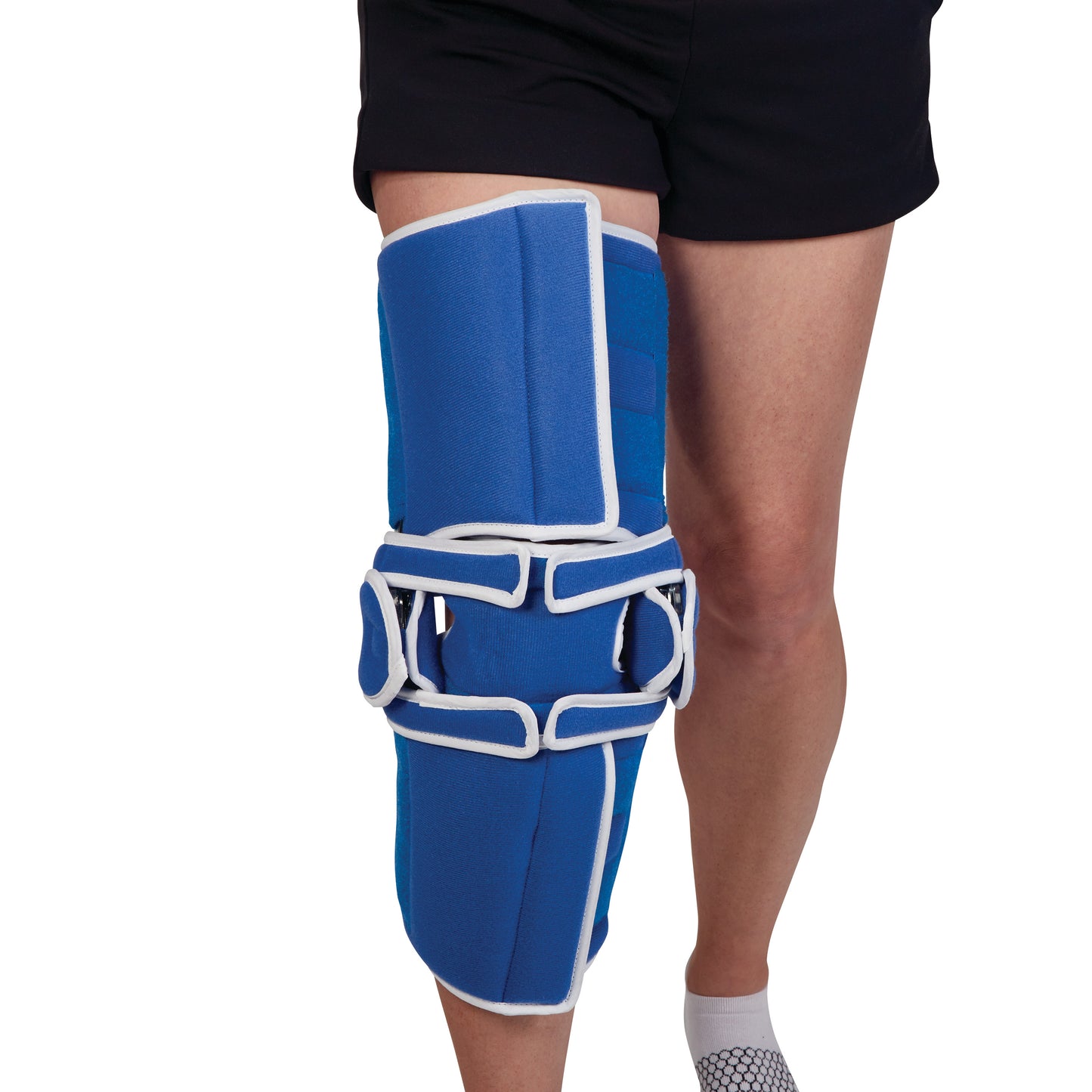 A person wears the AliMed Easy-On Knee Brace, a blue and white brace with adjustable straps on the right leg, paired with shorts.