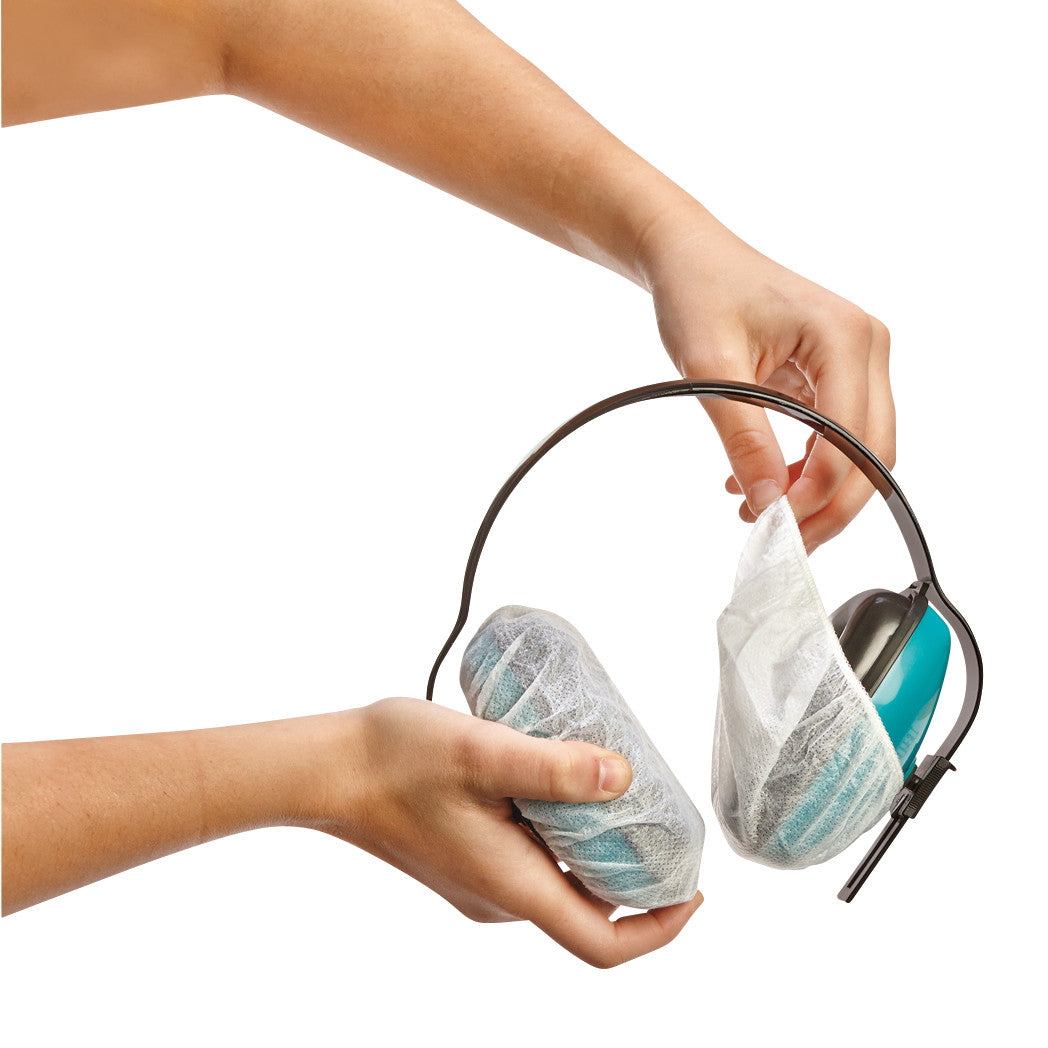 Hands apply AliMed Sanitary Headset Covers to blue headphones, using white disposable covers for hygiene protection.