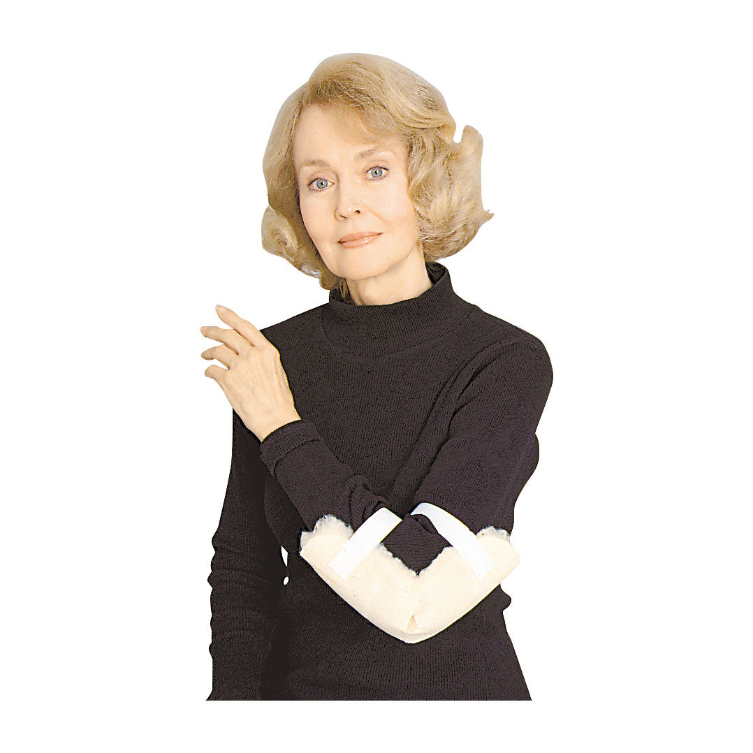 A person wearing a black turtleneck uses the SkiL-Care Elbow Protector, which is a padded support on their elbow secured with straps.