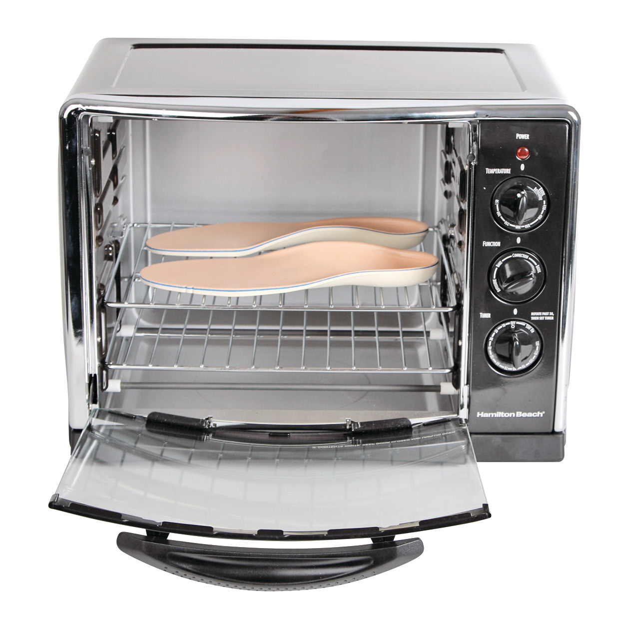 A pair of shoe insoles is placed inside an open Convection Oven, which has controls for temperature, function, and timer on the side.