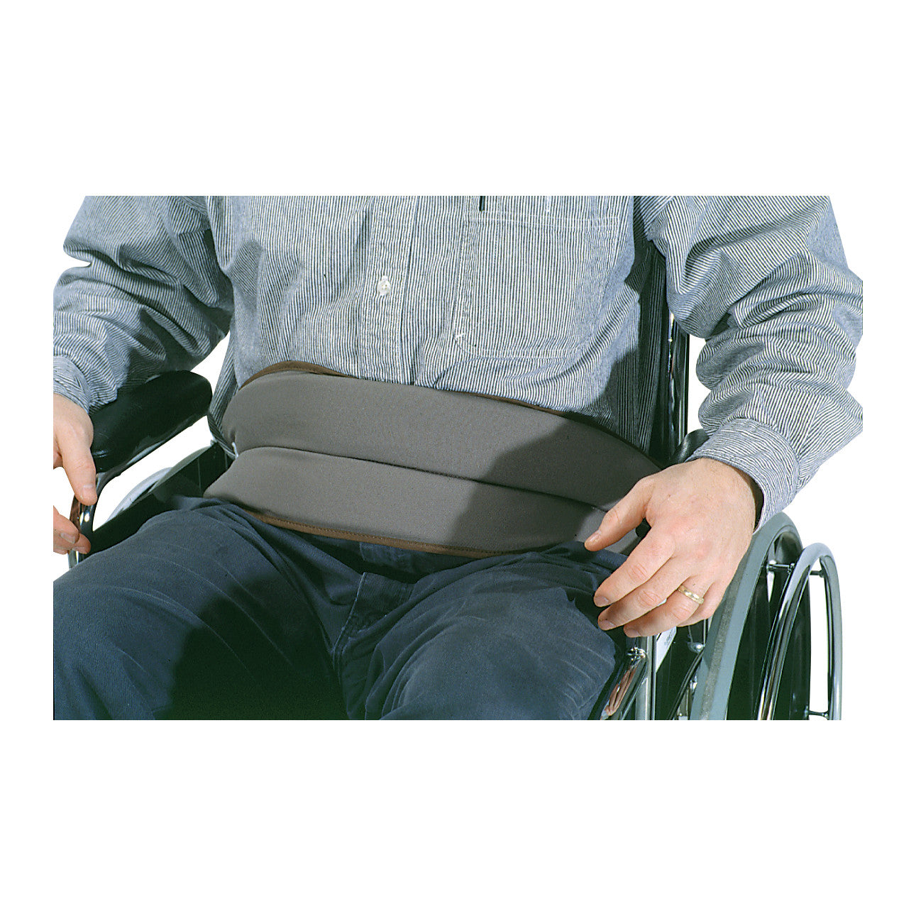 A person in a wheelchair wears the SkiL-Care Safety Foam Lap Restraint, securing them at the waist for added stability and safety.
