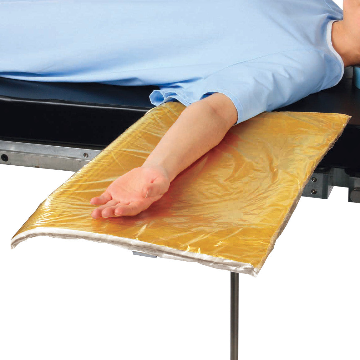 A patient's arm rests on an AliMed Mayo Stand Cover, a protective yellow pad on a medical table, secured with a blue gown.