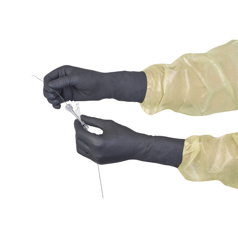 Two hands wearing FreeGuard 1 and 2 Attenuation Gloves handle a medical instrument with a green wire, against a white background.