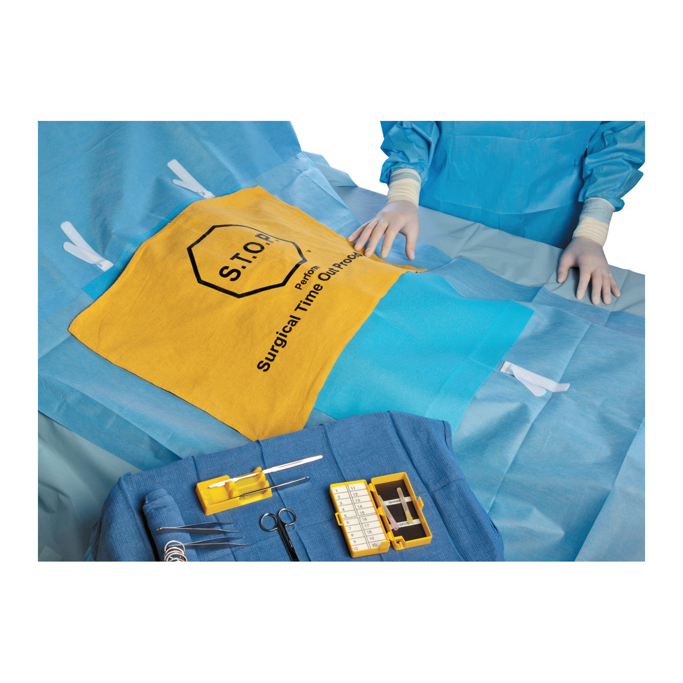 A surgical setup with a S.T.O.P. Safety Flag on the table, surrounded by medical tools and a person in blue surgical attire.