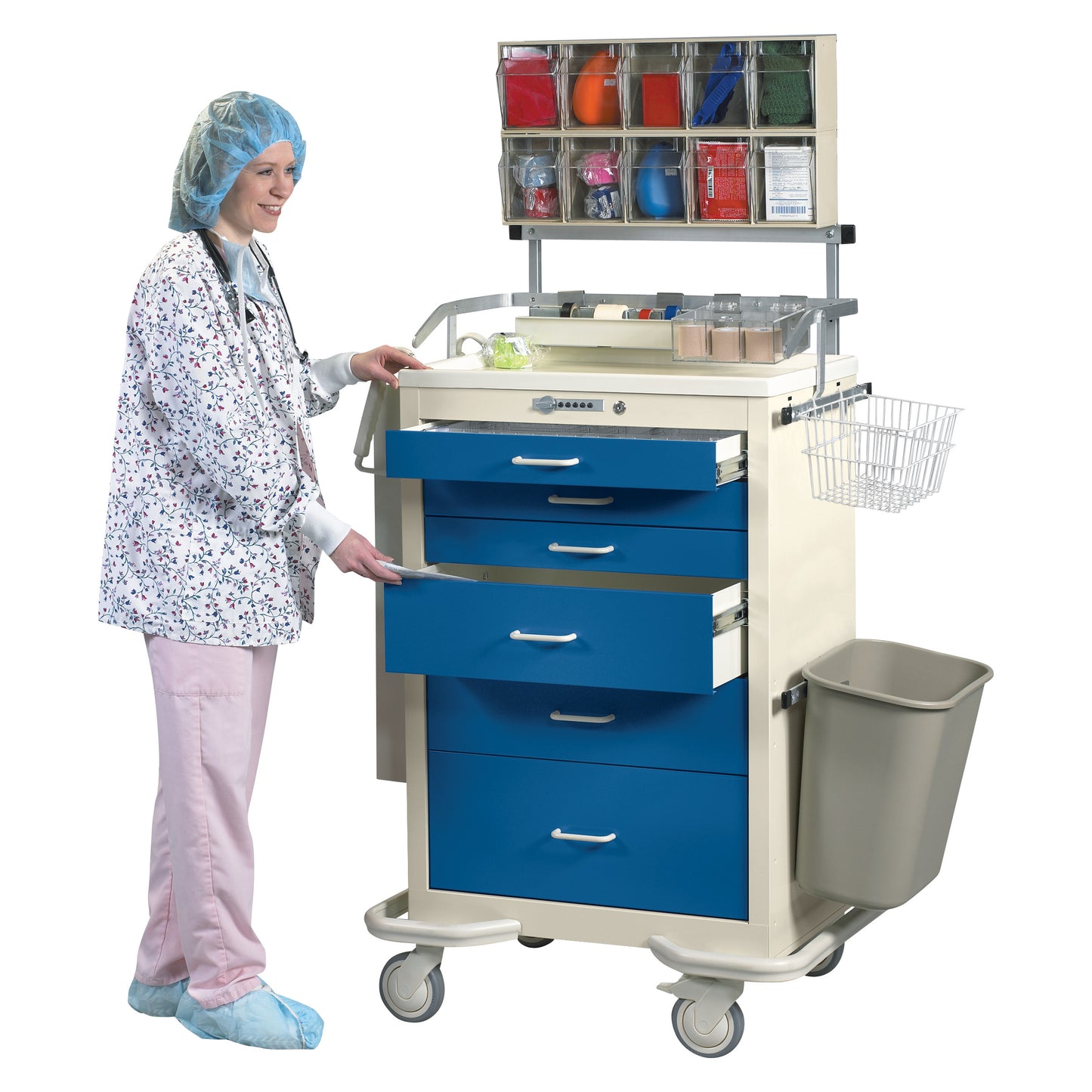 A healthcare worker in scrubs and a cap stands next to Accessory Packages for AliMed Standard Series Anesthesia Medical Carts, opening a drawer.
