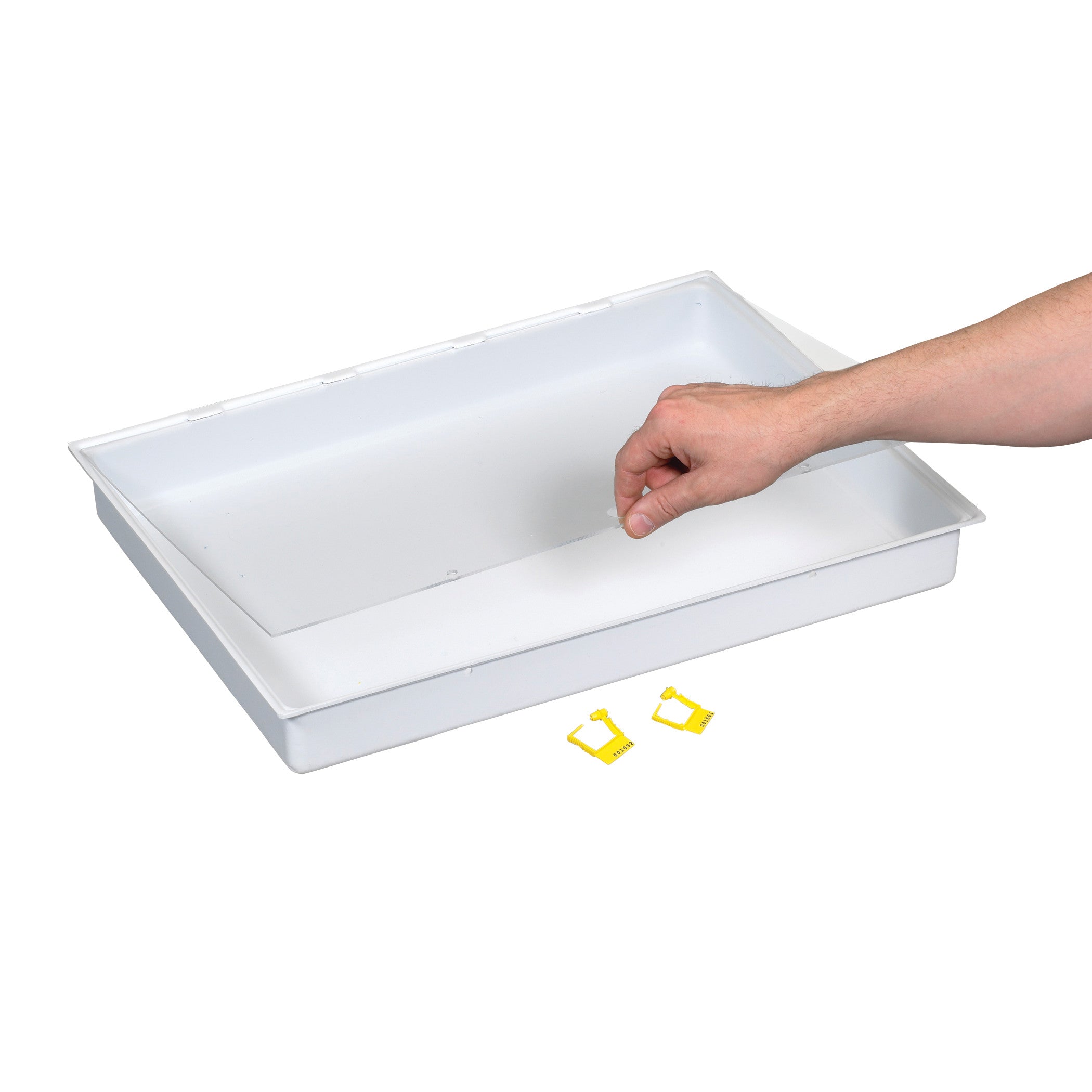 A hand reaches over a white AliMed Cart Accessory: Full Drawer Tray with Clear Lid and Lock, with yellow clips nearby.