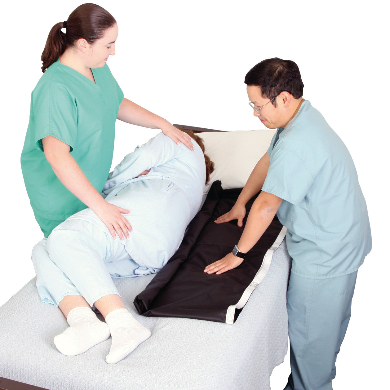 Two caregivers demonstrate the use of the AliMed No-Lift BOOSTER to reposition a patient in bed.