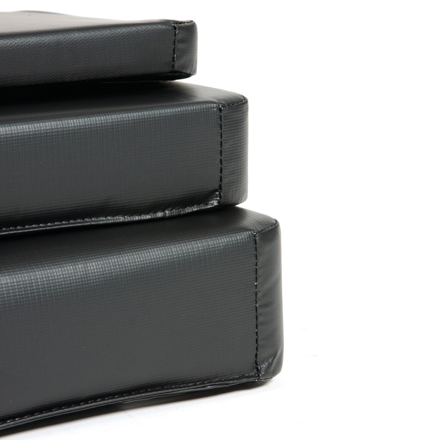 Close-up of stacked black AliMed Standard Armboard Pads, showing their textured surface and stitching.