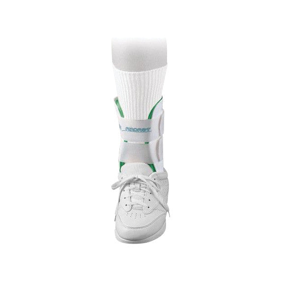An Aircast Air-Stirrup Ankle Brace worn with a white sneaker and sock. The brace is white with a green accent and a strap.
