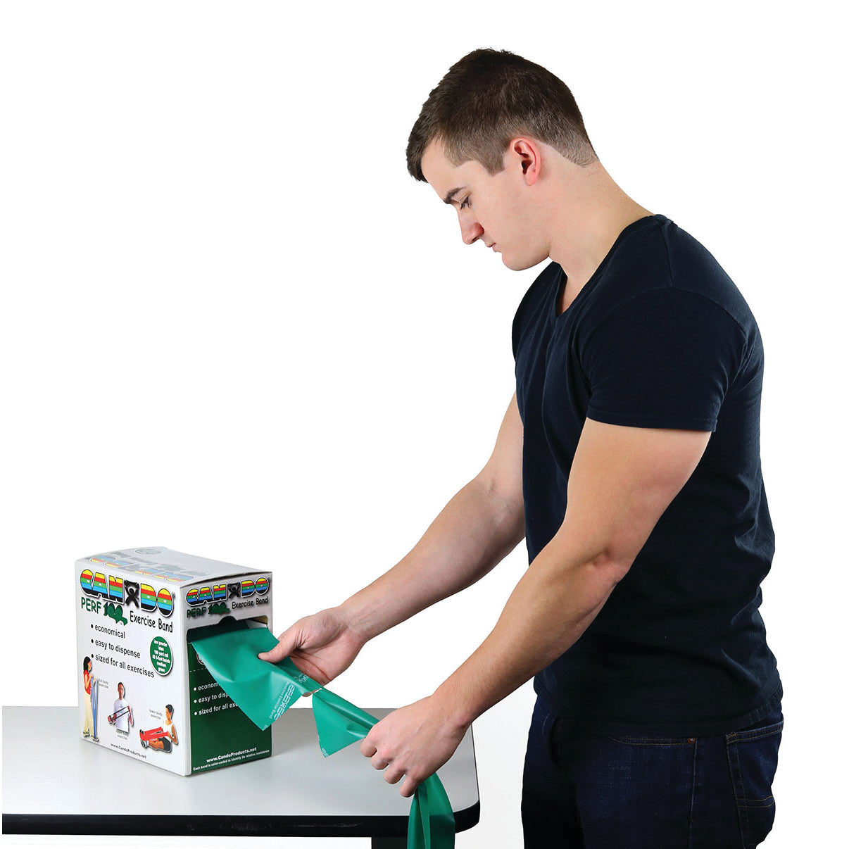 A person pulls a green CanDo Latex Exercise Band from a dispensing box on a table.