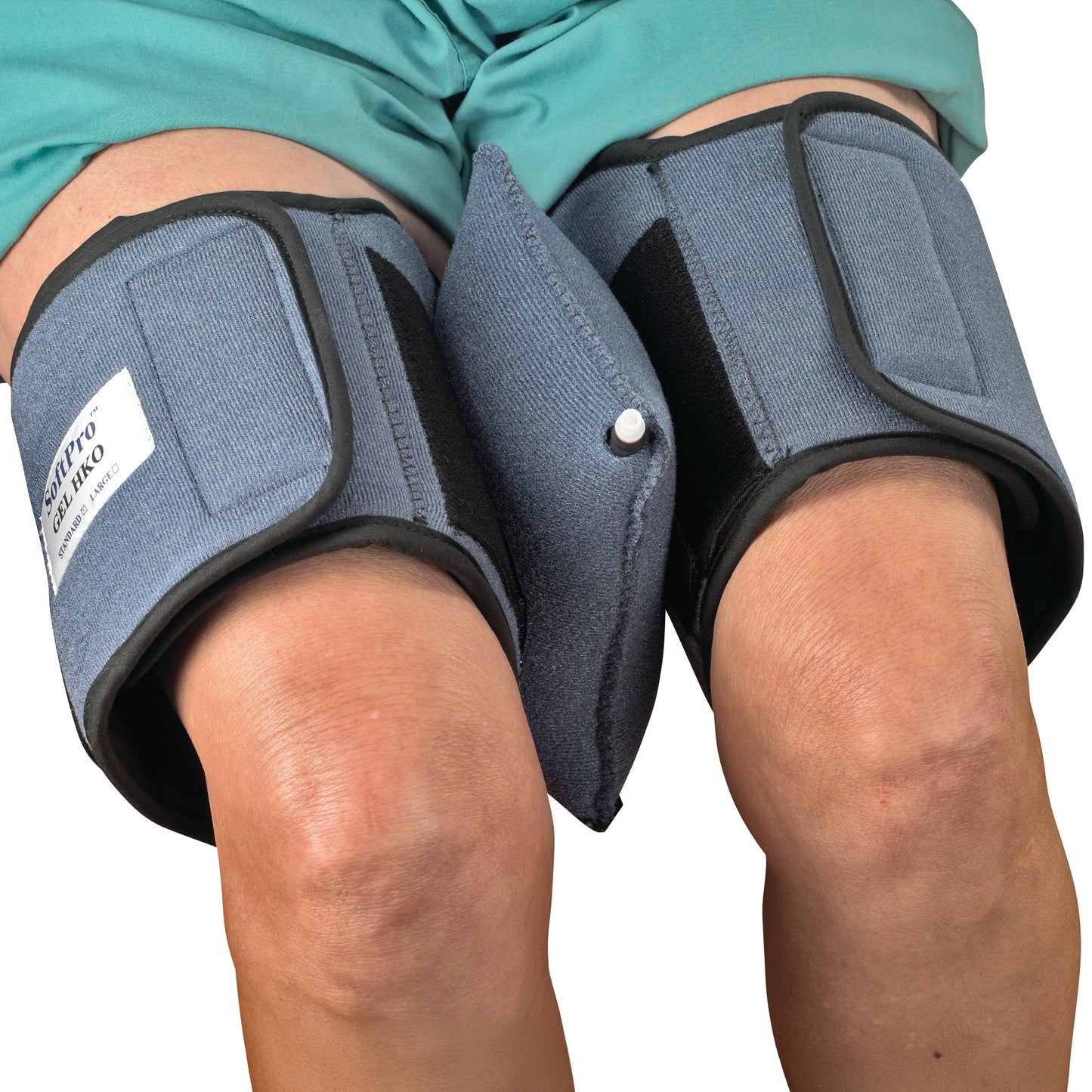 Person wearing the OCSI SoftPro HKO (Hip/Knee Orthosis) with blue knee wraps and a connected cushion pad for post-surgery support.