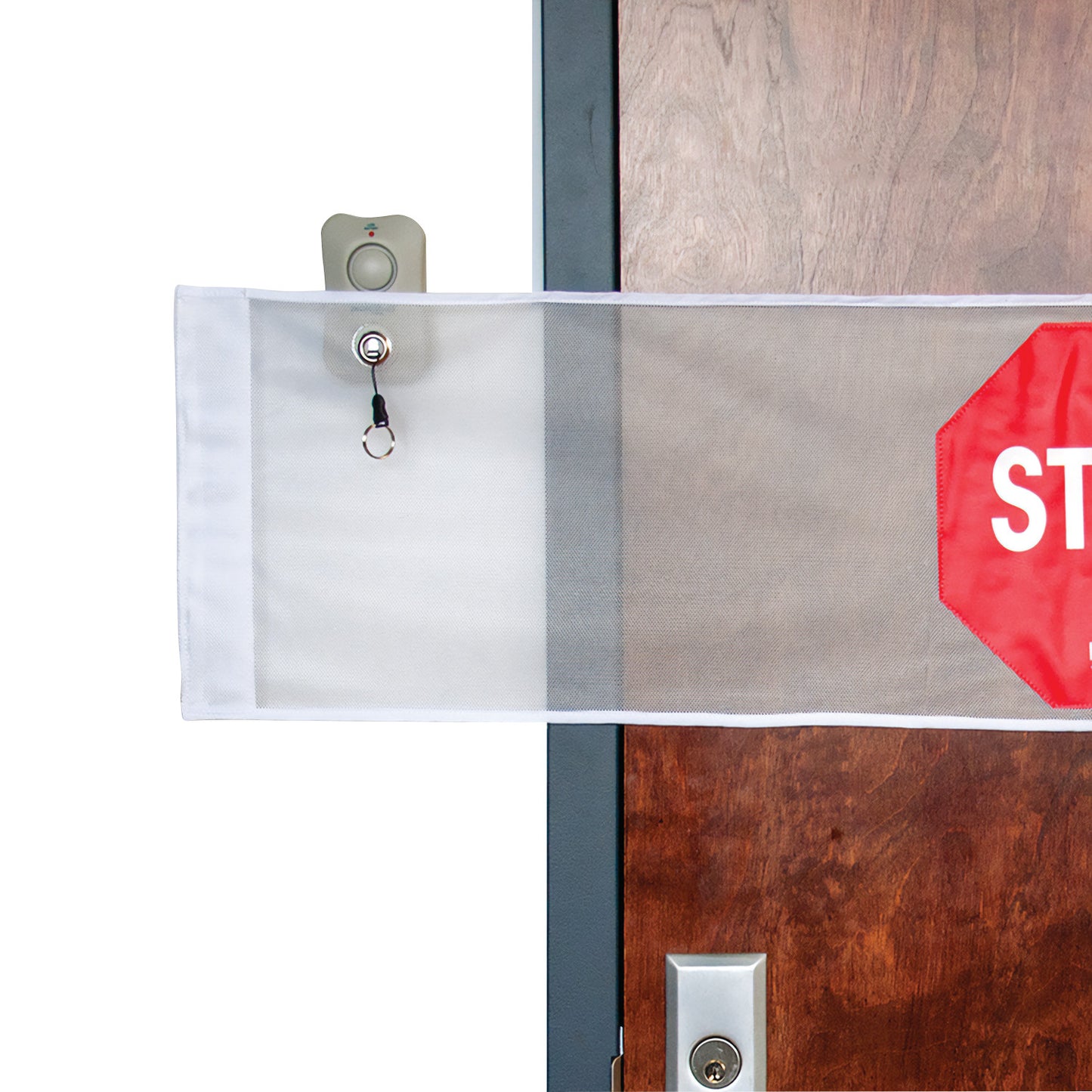 The NYOrtho Door Guard Stop Sign with Alarm is attached to a wooden door, featuring a red stop sign on a white mesh panel.