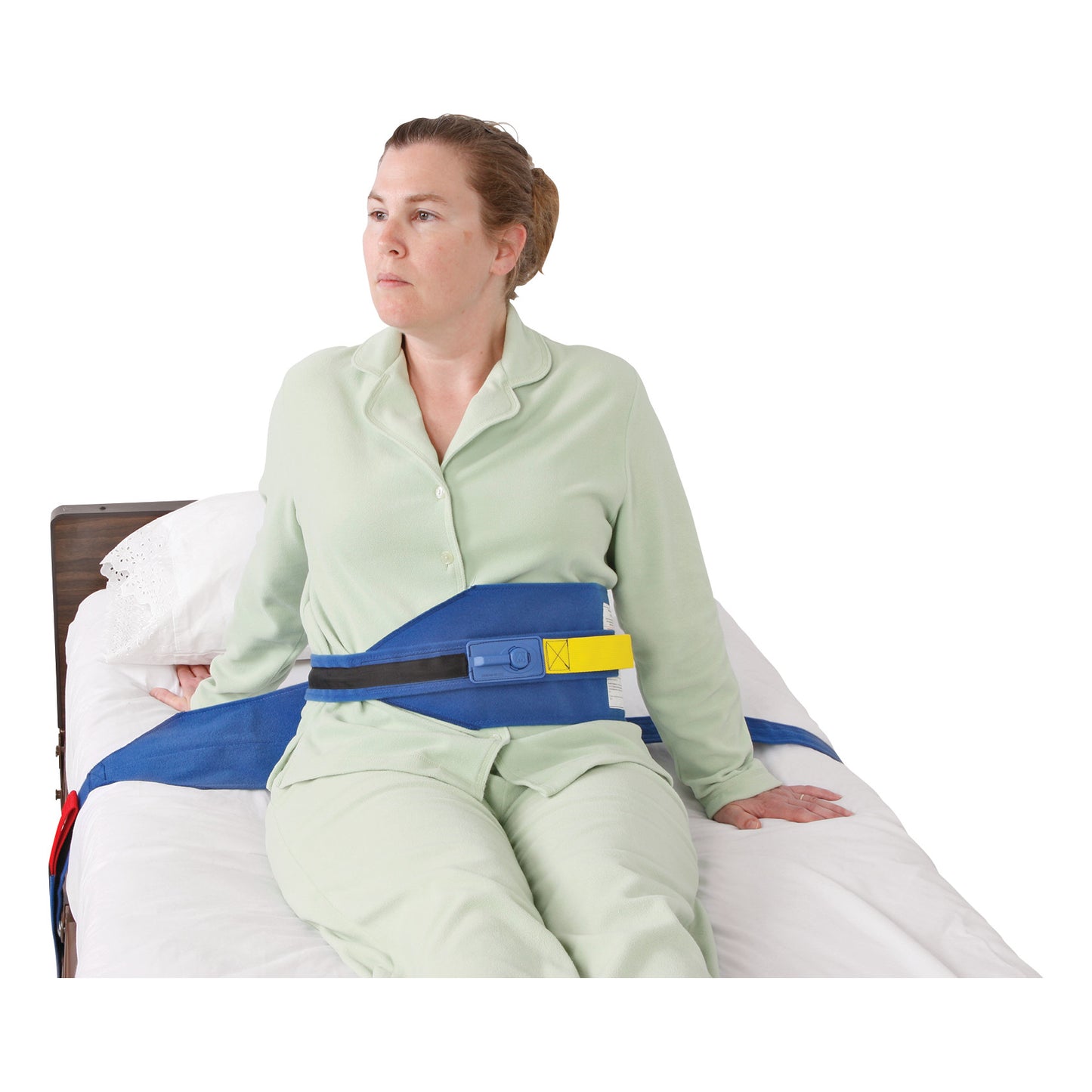 A person sits on a bed wearing an AliMed Roll-Control Belt, a blue safety restraint with a yellow and black buckle.