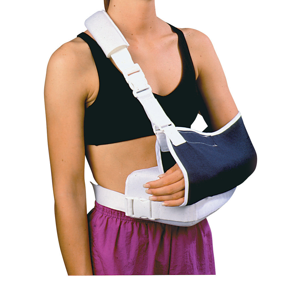 A person wears a Shoulder Immobilizer with Contoured Arm Wedge and Body Strap, featuring a padded shoulder and arm support.