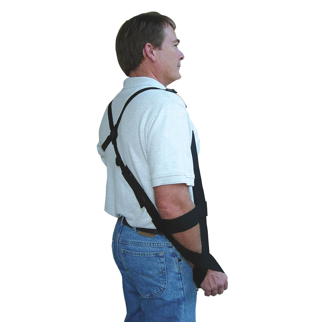 A man wears a GivMohr Sling, a shoulder strap device, offering arm support. He faces sideways, wearing a white shirt and jeans.