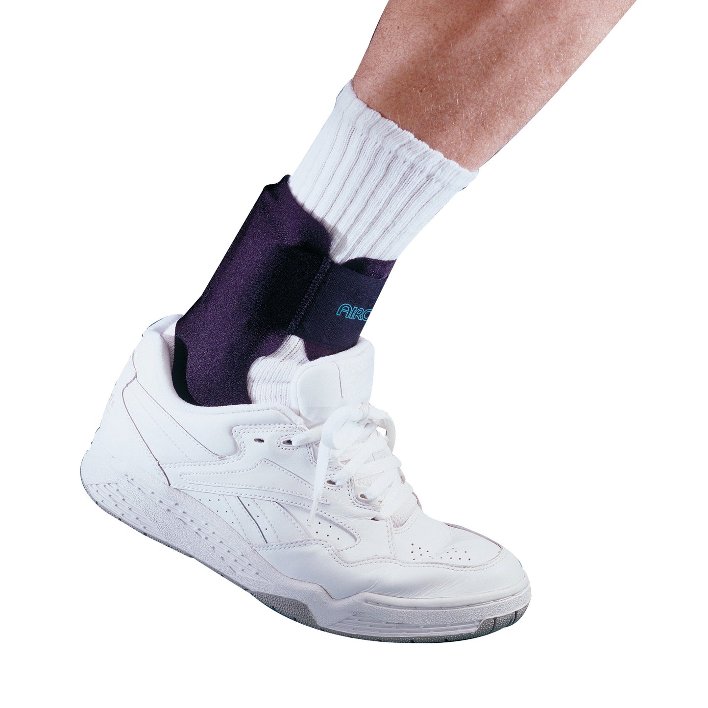 A person wears the Aircast Airheel Brace over a white sock and white sneaker for ankle support.