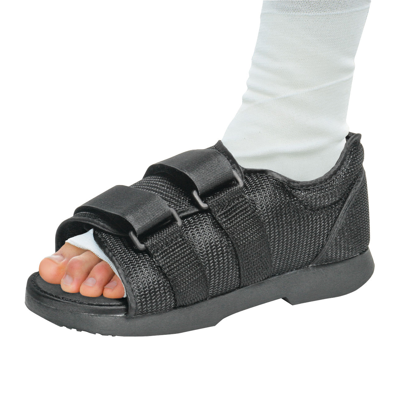 A foot wearing the AliMed Pediatric Classic Post-Op Shoe with adjustable straps. The shoe is black with an open toe design.