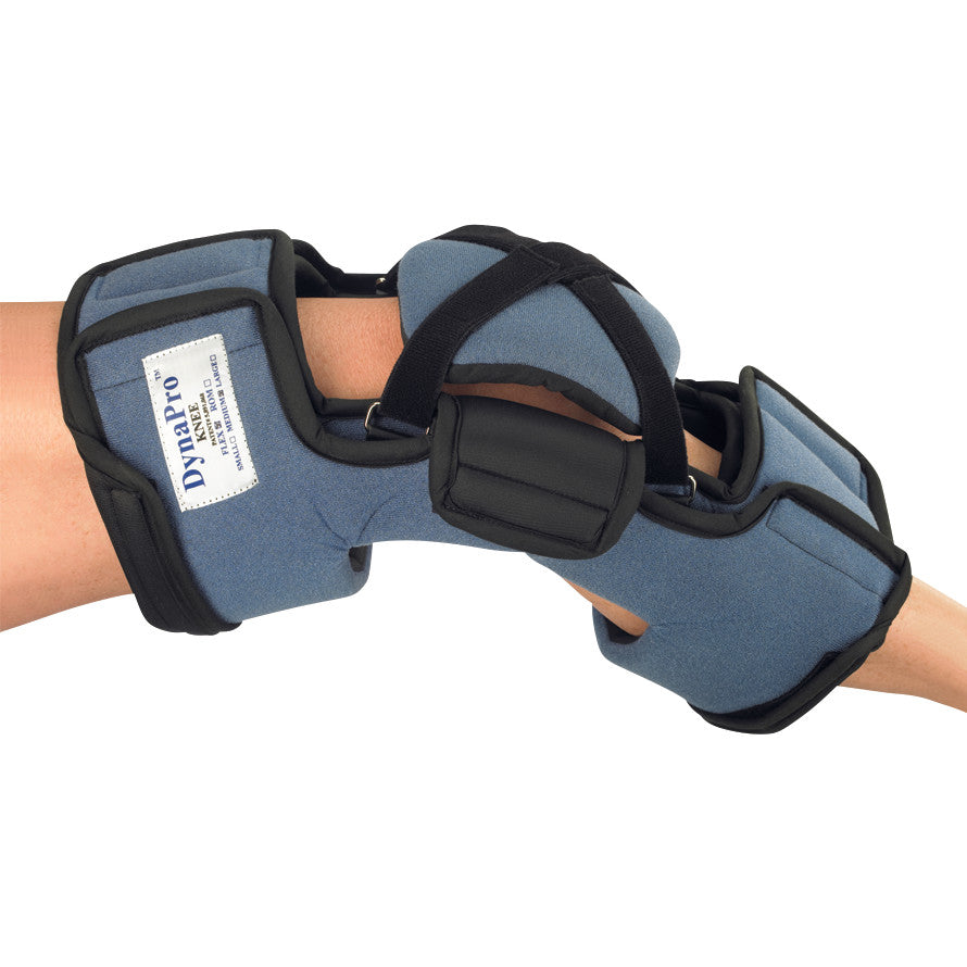 A person wears an OCSI DynaPro Flex Knee Orthosis with black straps and blue padding for support and stabilization.
