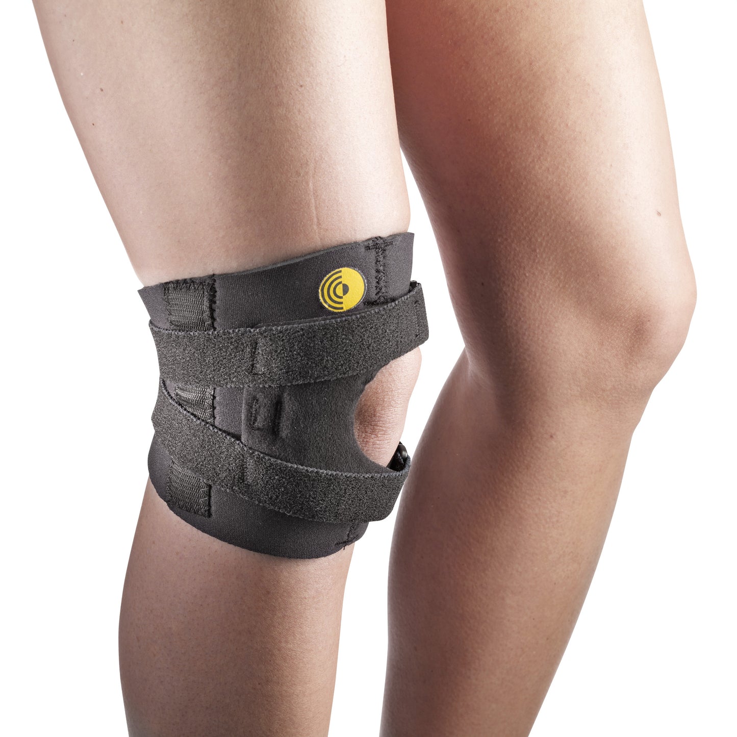 A person wearing a 6"L Knee-O-Trakker Knee Brace with Hinge, featuring black straps and a yellow logo, providing knee support.