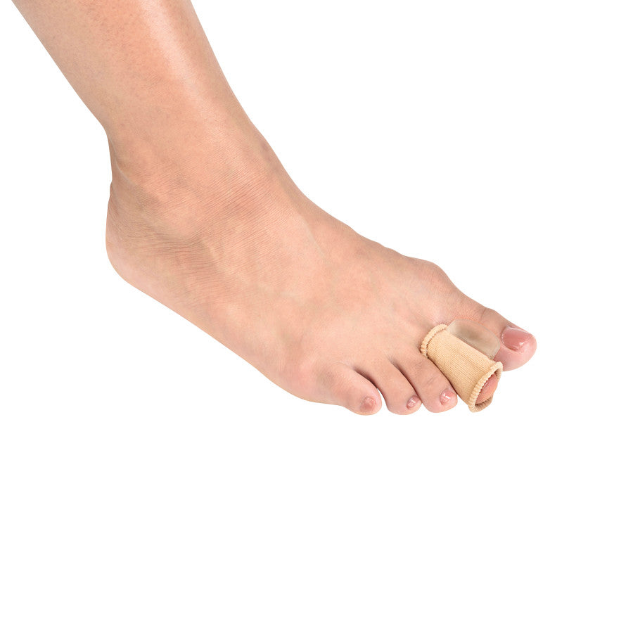 A foot with a Silipos No-Slip Toe Spacer on the second toe, separating it from the others. It is beige and tube-shaped.