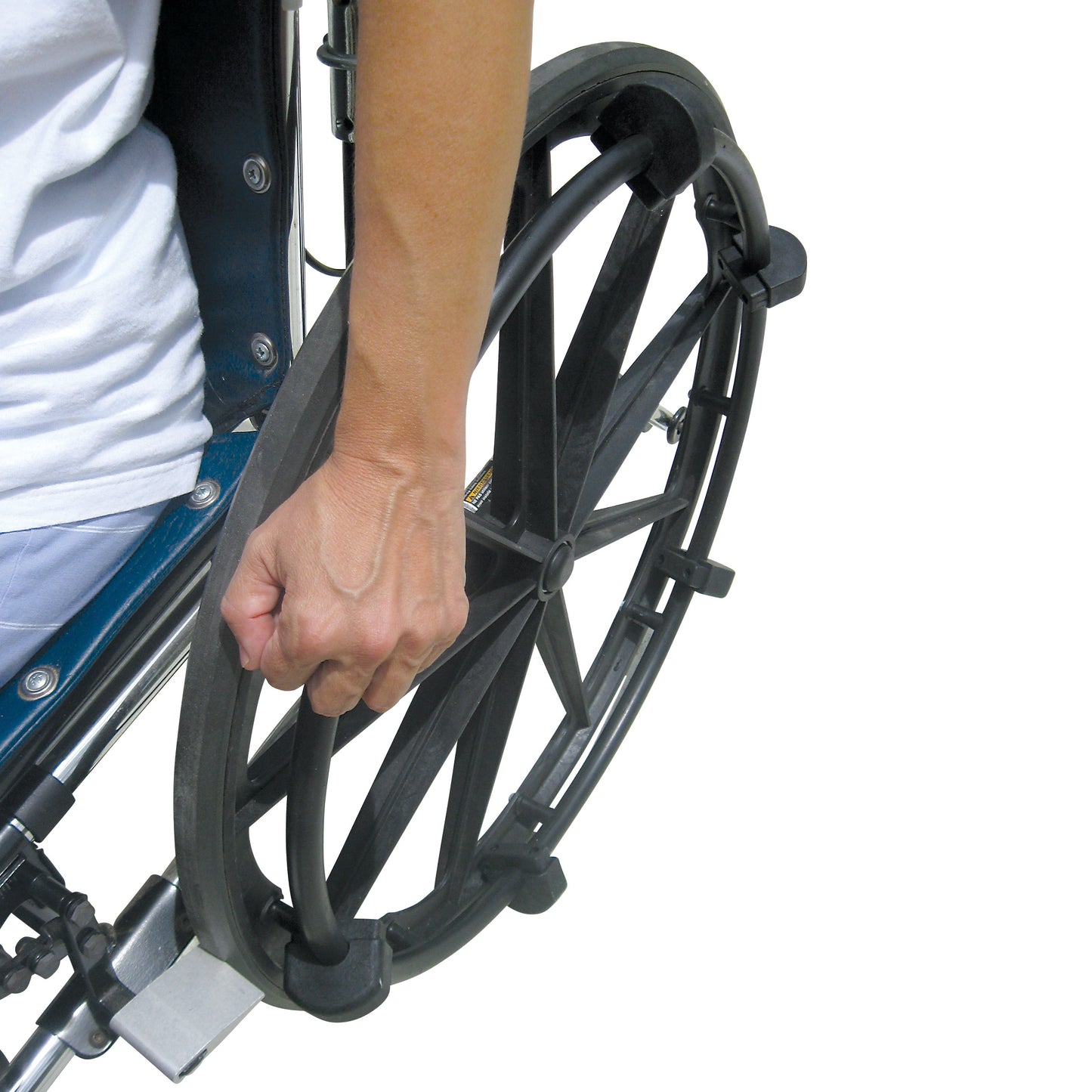 A person grips a wheelchair wheel using the Shove-a-Lugs Wheelchair Grip Attachment, designed for improved control and ease.