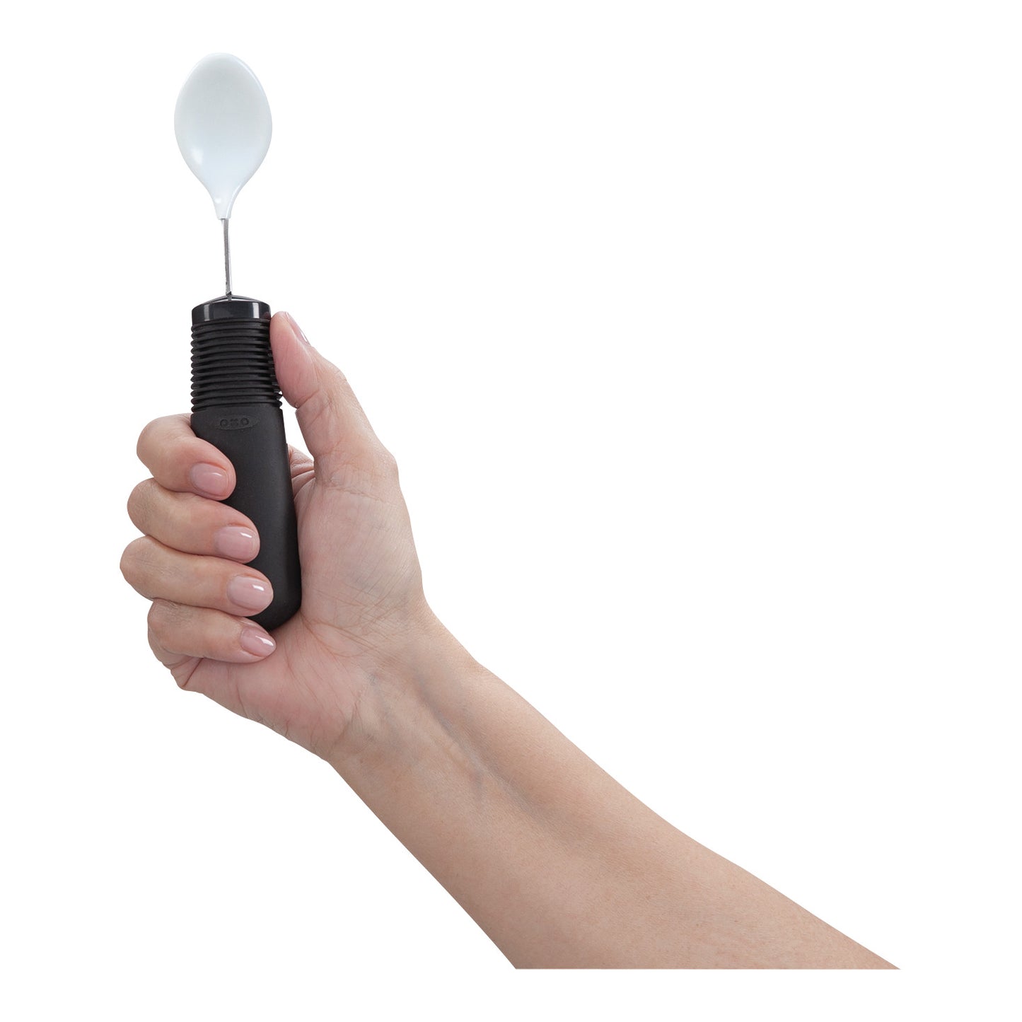A hand holds a Good Grips Coated Teaspoon, featuring a large black handle with a textured grip and a small white spoon bowl.