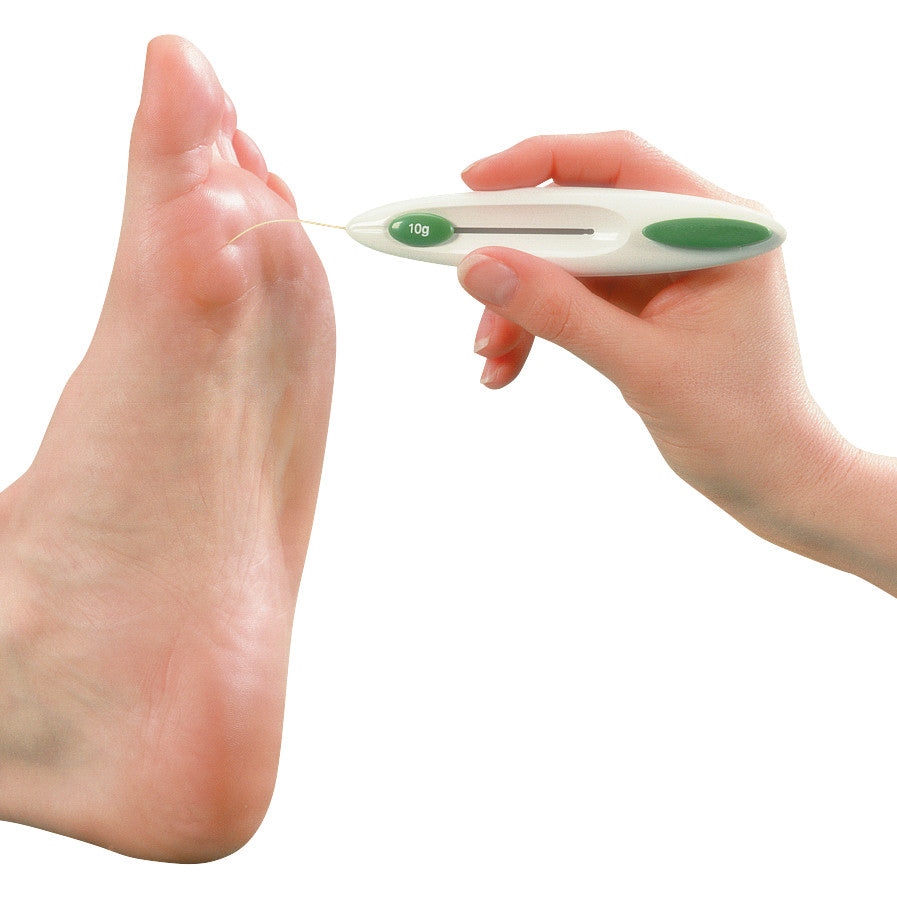 A hand uses the Baseline Retractable Monofilament tool to test the sensation on a bare foot.