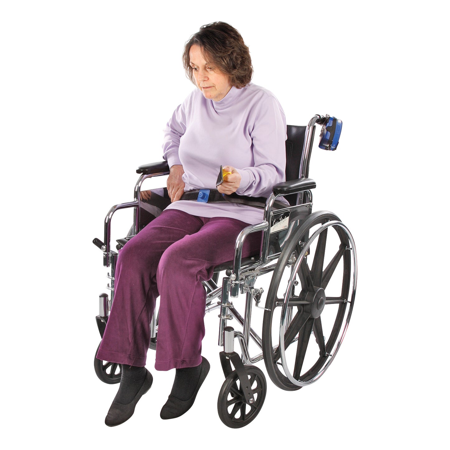A person in a wheelchair wearing the AliMed Early Warning E-Z Release Seatbelt, dressed in a light purple top and purple pants.