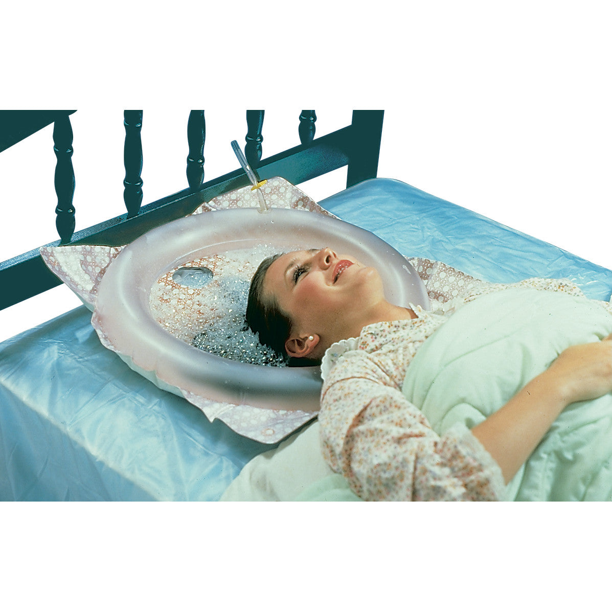 A person using a Shampoo Tray in bed. The tray supports the head with soapy water, allowing hair washing without leaving bed.
