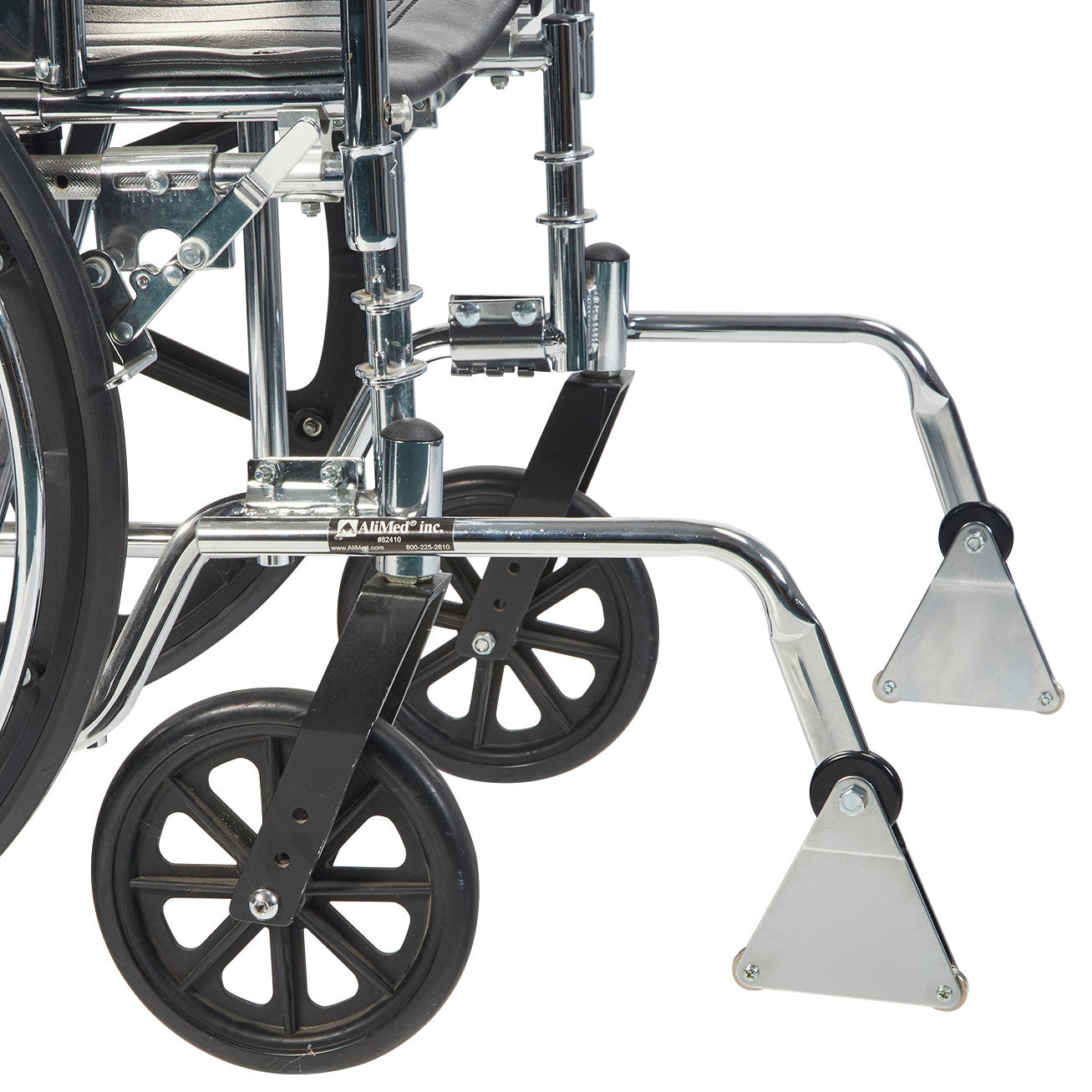 Close-up of the AliMed Front Anti-Tipper with Bumper attached to a wheelchair, featuring small black wheels and metal support.