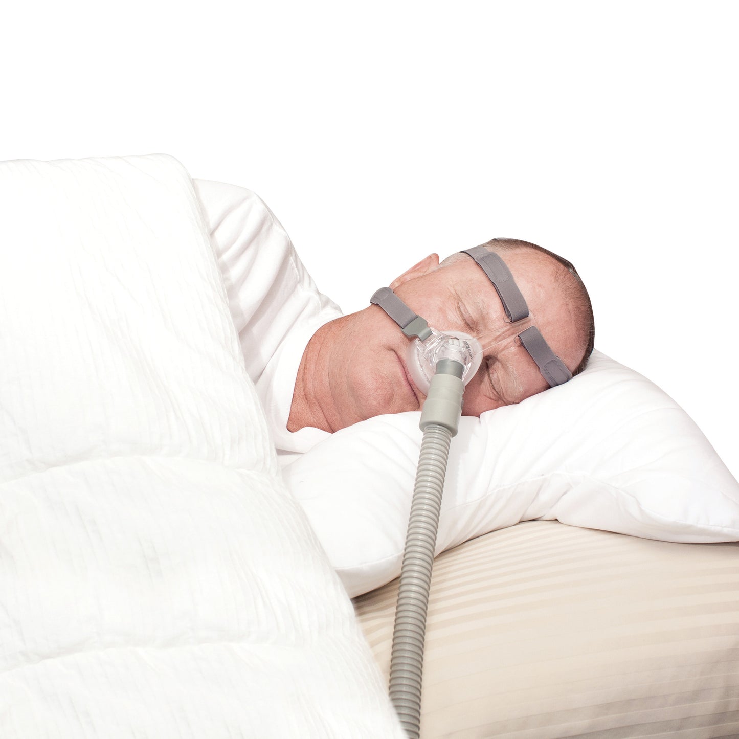 A man uses a SleePAP Pillow designed for CPAP users, wearing a CPAP mask while sleeping, with a hose connected to the mask.