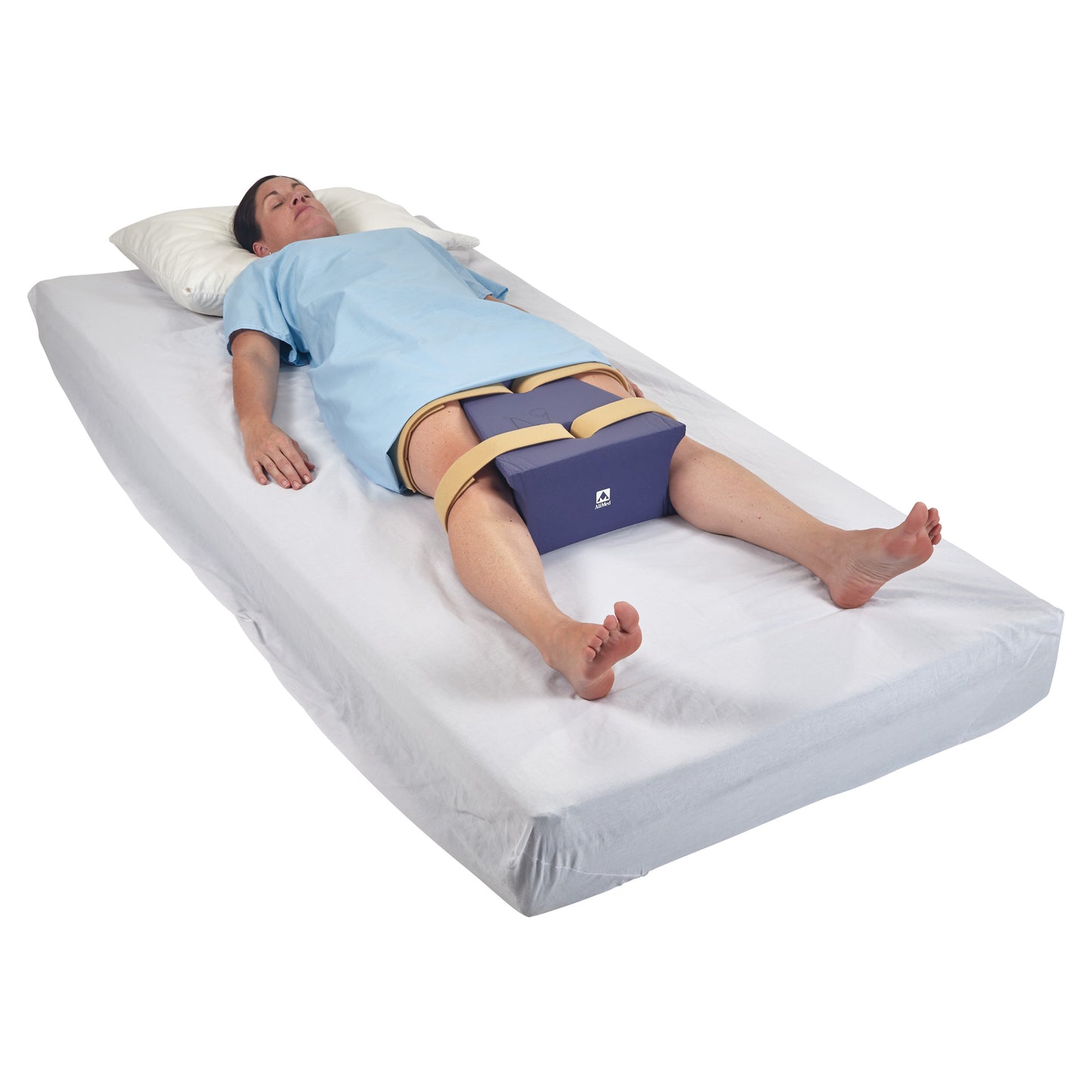 A person lies on a bed with an AliMed Waterproof Abduction Pillow strapped between their knees, wearing a blue gown.