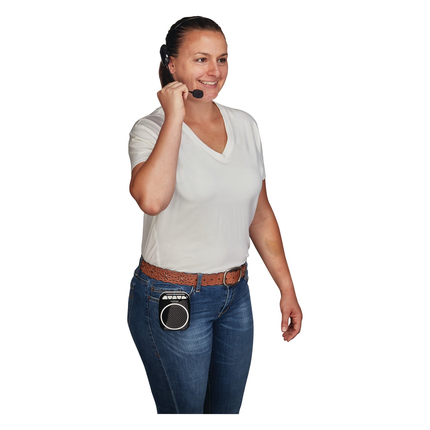 A woman wearing a headset and a Portable Voice Amplifier clipped to her jeans. She is smiling and wearing a white shirt and jeans.