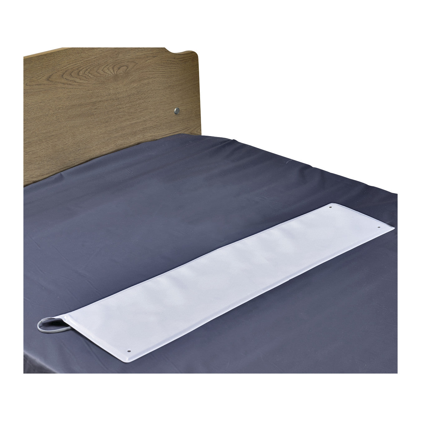 The SkiL-Care OverMattress Bed Sensor Pad is placed on a dark gray bed sheet with a wooden headboard in the background.