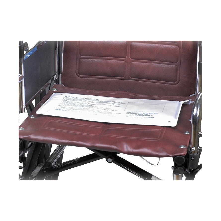 A SkiL-Care Chair Sensor Pad is placed on the seat of a maroon wheelchair.
