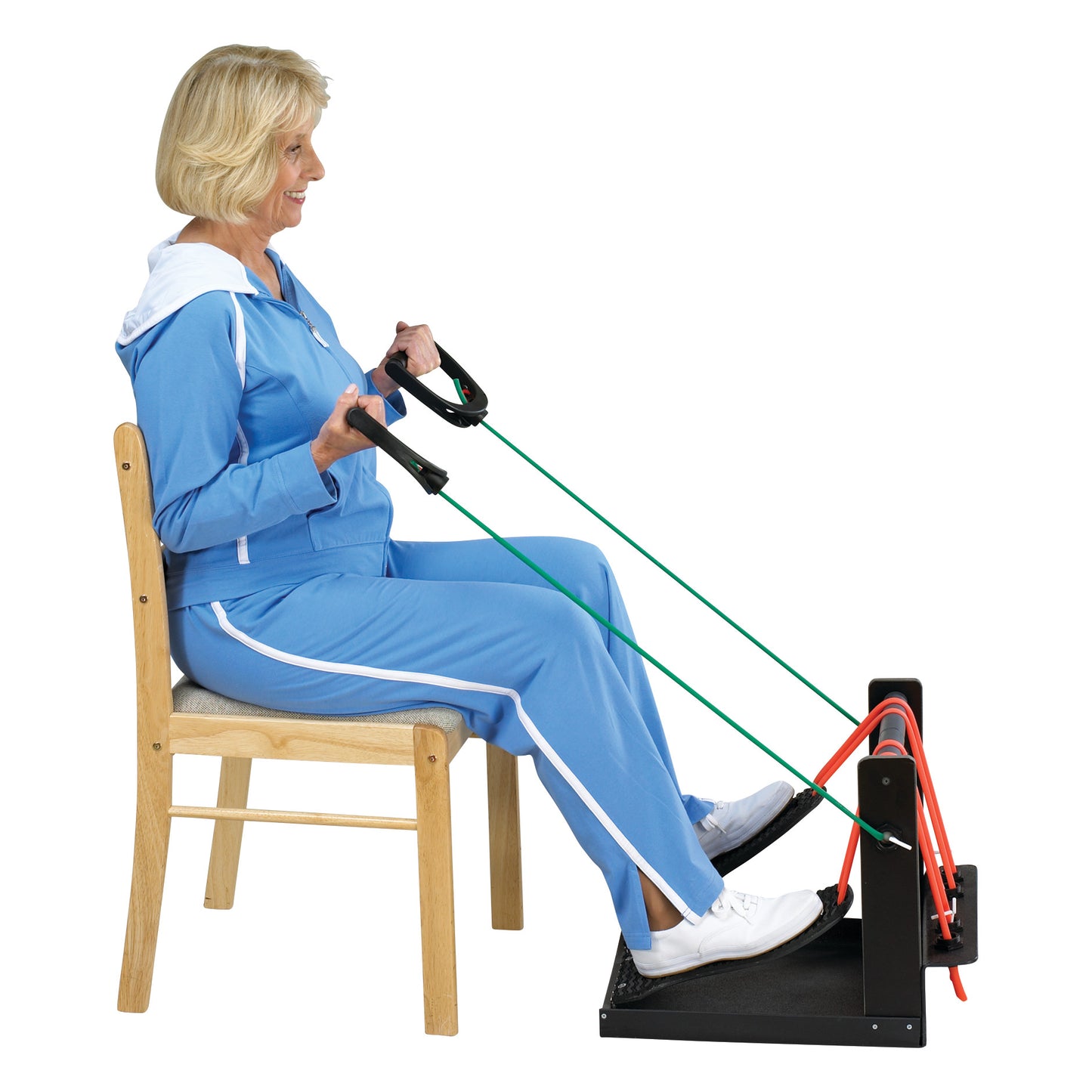 A person in a blue tracksuit uses the SkiL-Care Exercise Box with resistance bands while seated on a wooden chair.