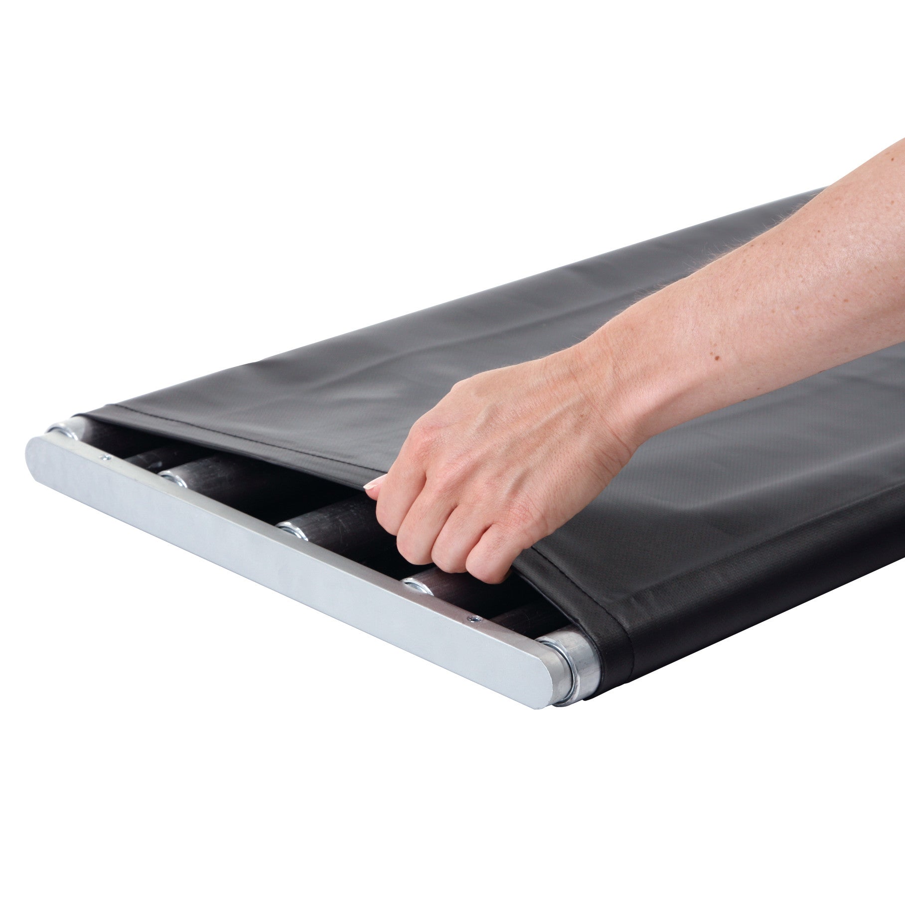 A hand adjusts a black Replacement Cover for AliMed Patient Roller, revealing the rollers underneath on a flat surface.