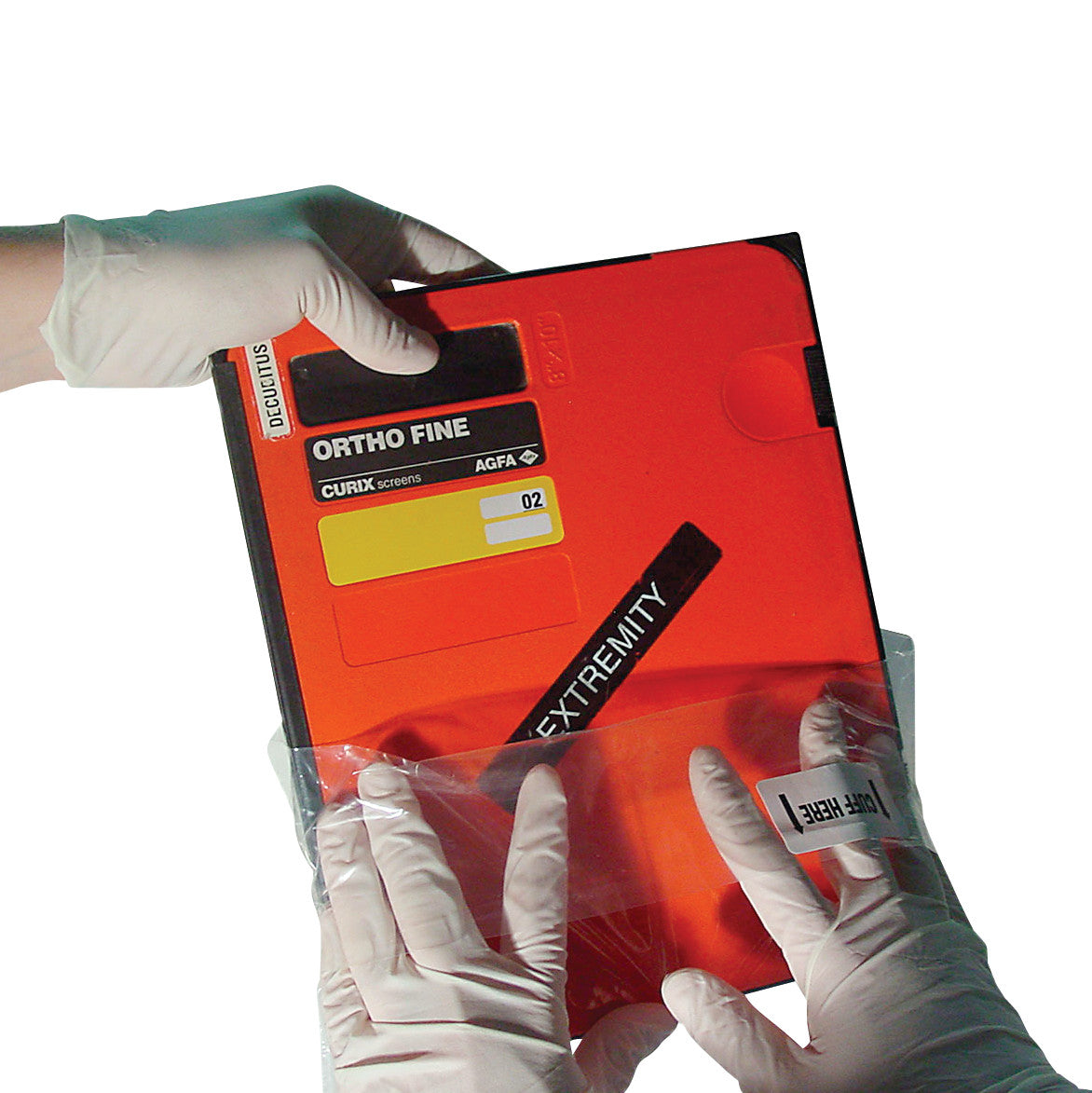 Gloved hands hold a Clear Poly Sterile X-Ray Cassette Cover containing an orange X-ray cassette labeled "ORTHO FINE."