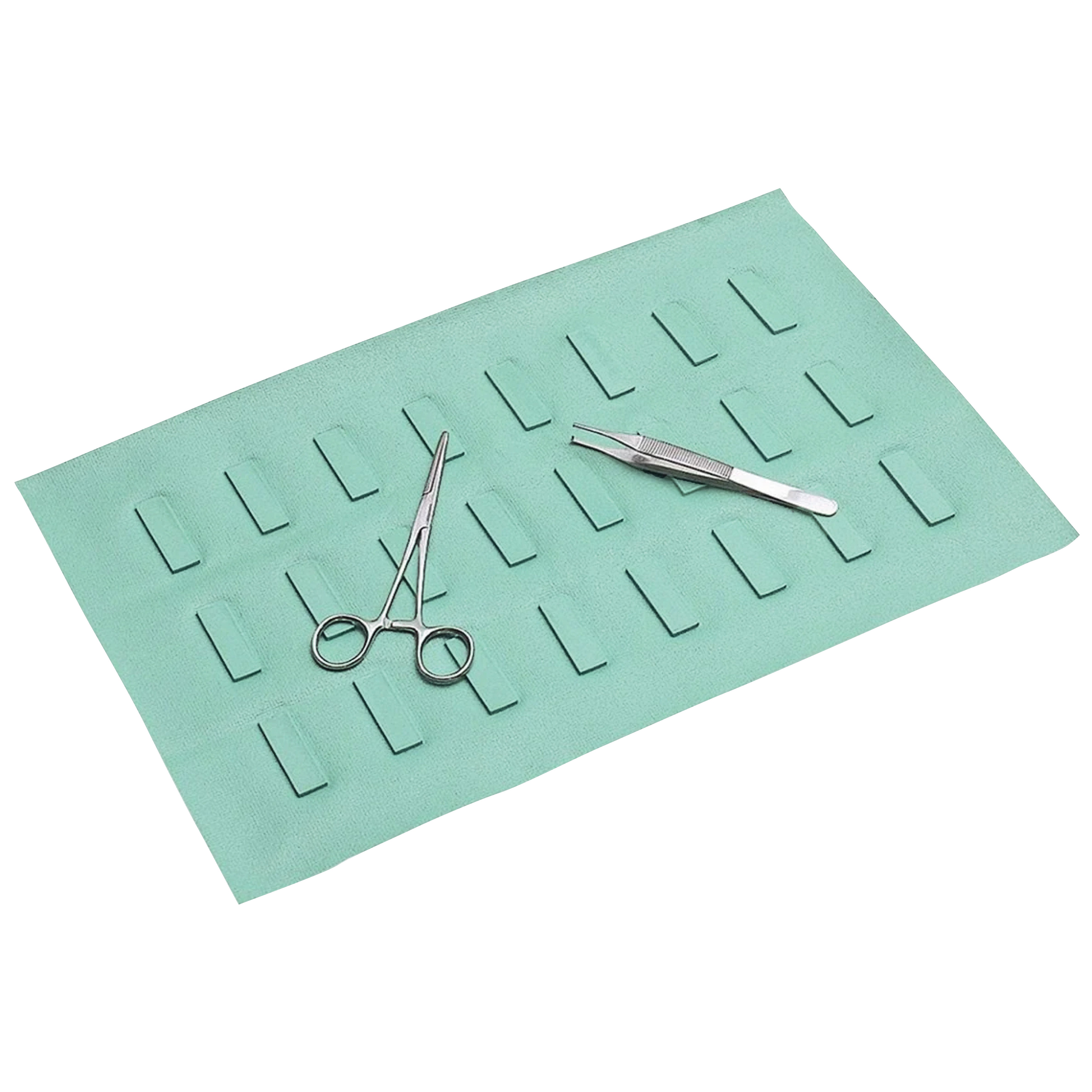 Green Hands-Free Transfer Disposable Magnetic Drape with slots, holding surgical scissors and forceps on its surface.