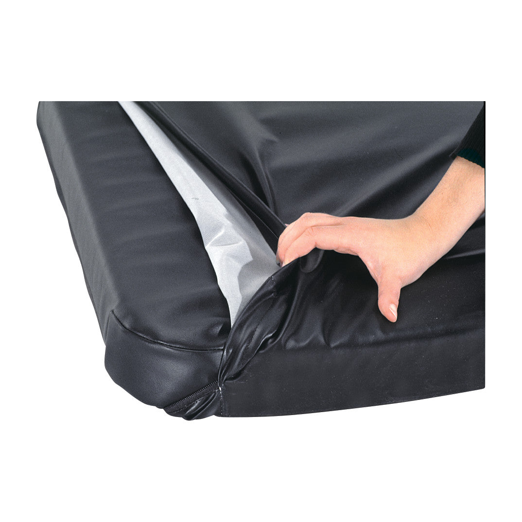 A hand holding the AliMed Stretcher Surface Replacement Cover, showing its black, smooth surface and edge detail.