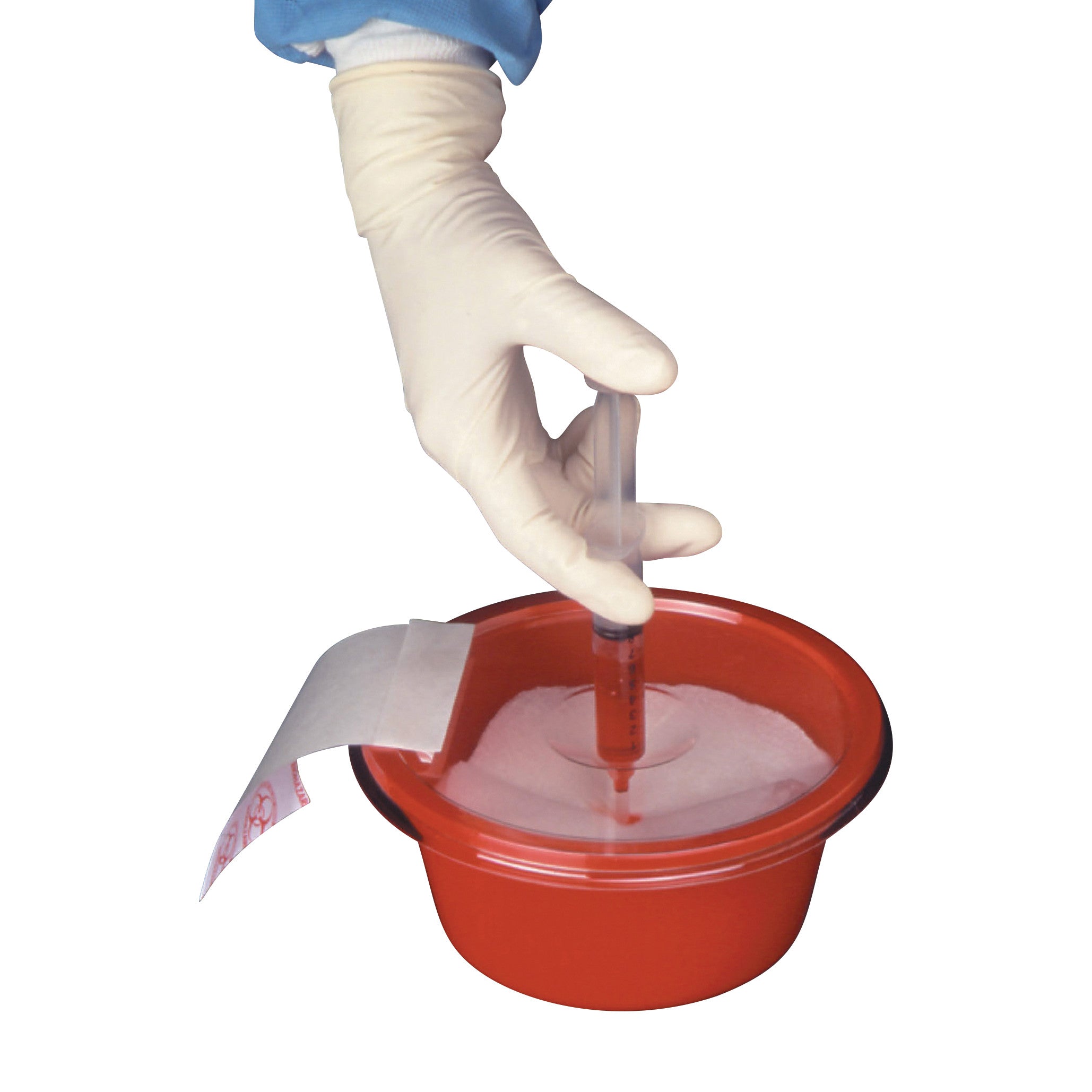 A gloved hand places a syringe into a Splash Stop Waste Collection Bowl, a red container designed for safe waste disposal.